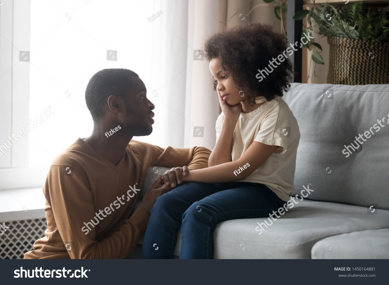 Loving african American father talk with upset preschooler daughter helping with problem, caring black young dad speak with sad girl child holding caressing hand, show support and understanding #1450164881