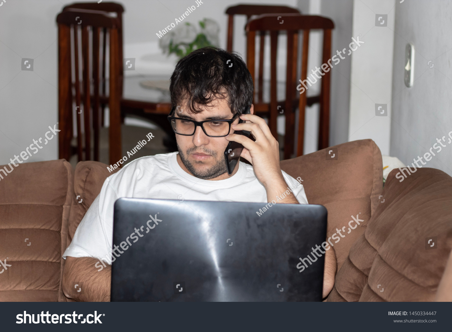 Man working with notebook and talking on cell phone at home office #1450334447