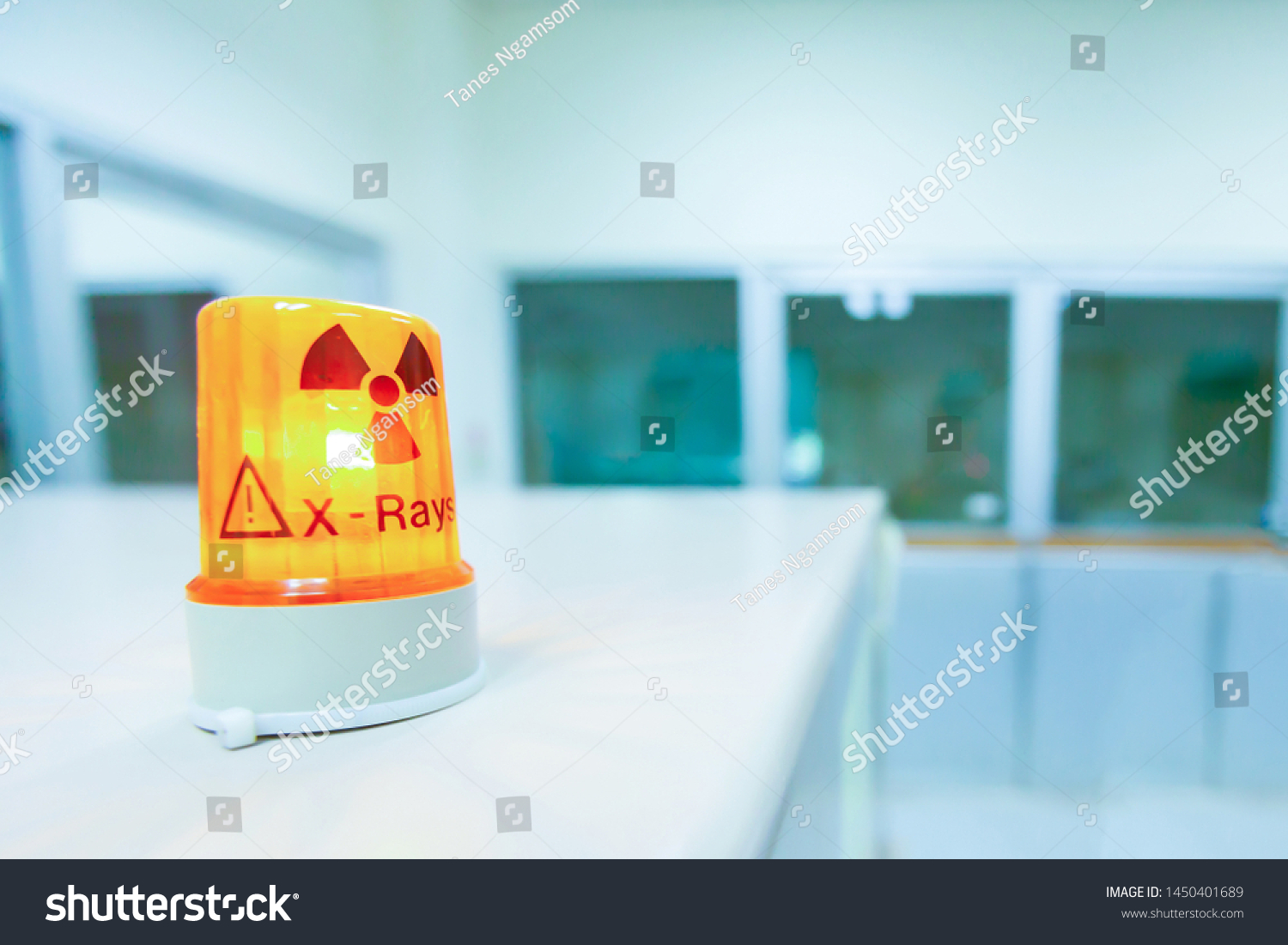 Ionizing radiation hazard symbol in x-ray laboratory, blurred laboratory interior for background. #1450401689