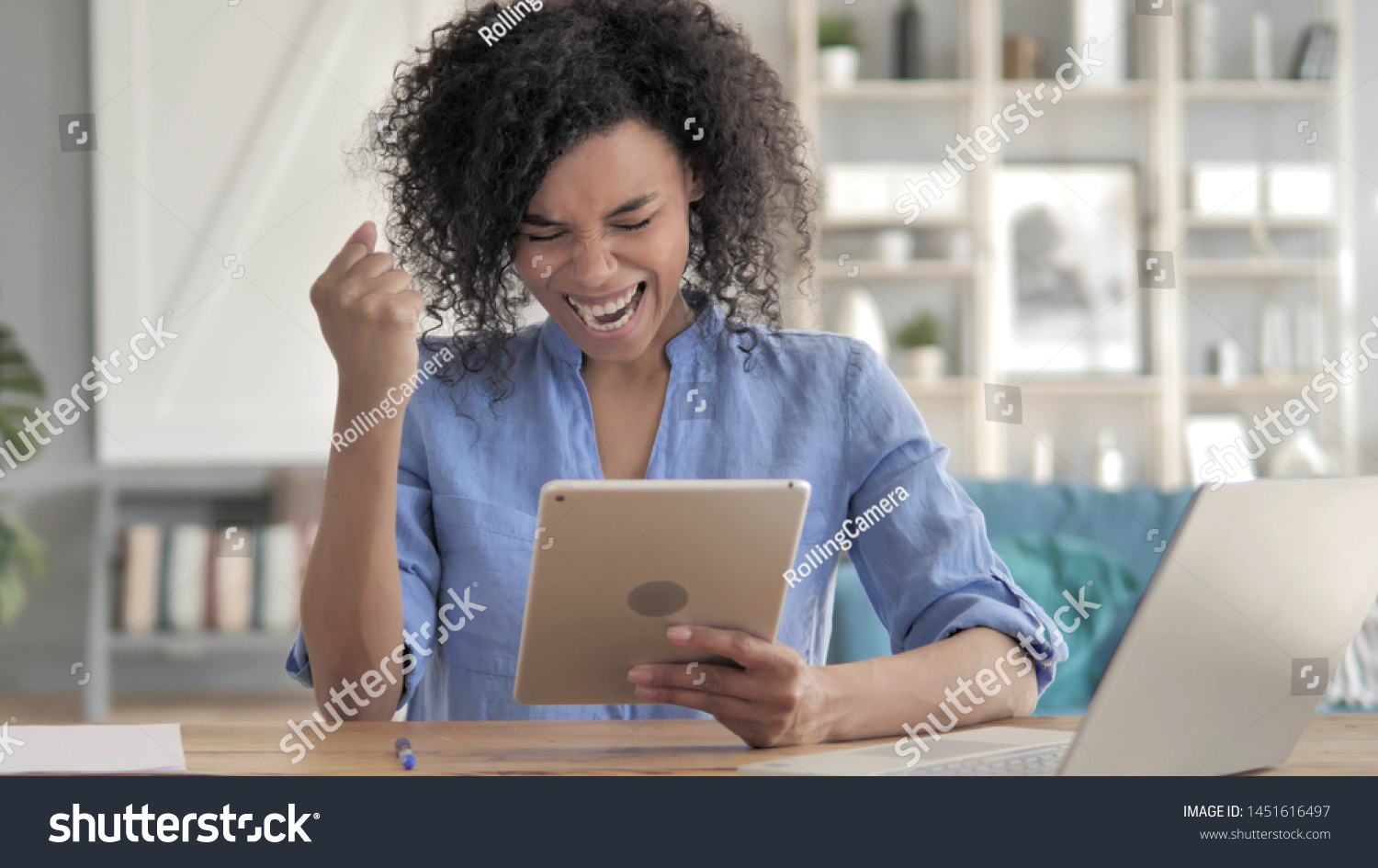 African Woman Celebrating Success on Tablet #1451616497