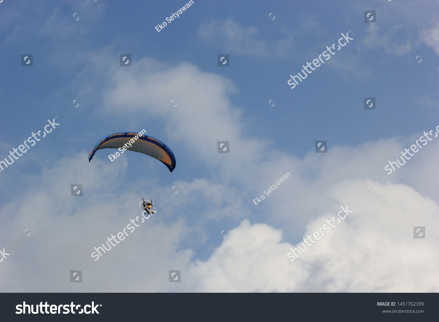 Paragliding pilots are flying over the clouds of Parangkusumo beach, Yogyakarta, Indonesia. February 17, 2018 #1451762399