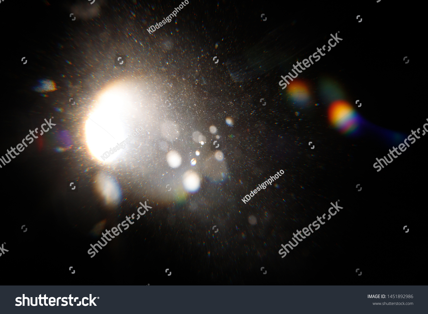 Lens Flare. Light over black background. Easy to add overlay or screen filter over photos. Abstract sun burst with digital lens flare background. Gleams rounded and hexagonal shapes, rainbow halo. #1451892986