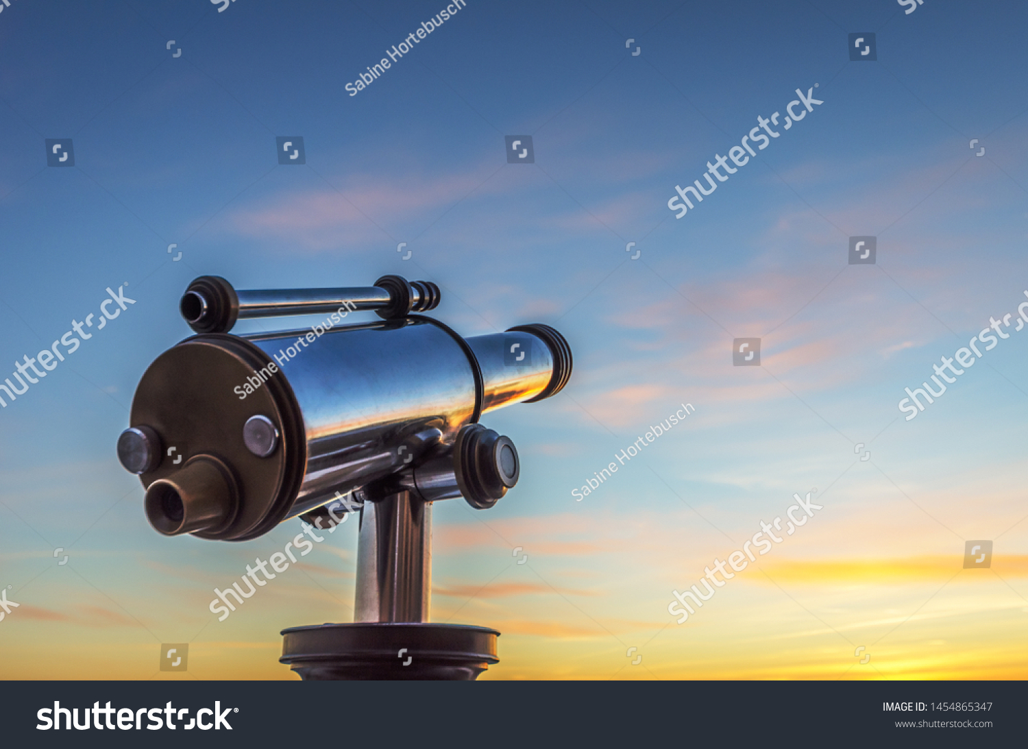 Monocular telescope at sunset with a cloudy sky #1454865347