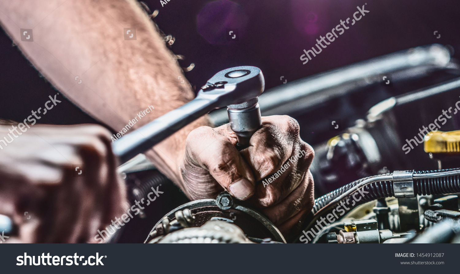 Auto mechanic working on car engine in mechanics garage. Repair service. authentic close-up shot #1454912087
