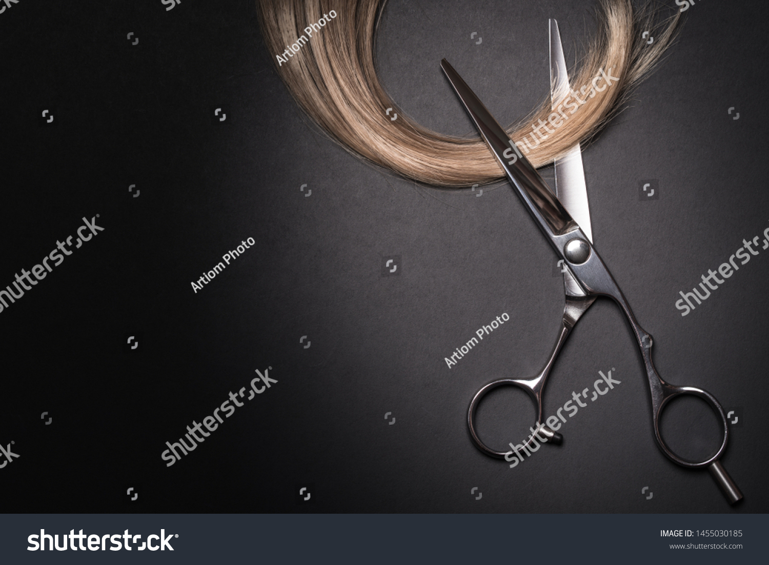 Scissors and piece of blond hair. Professional barber hair cutting shears on black background. Hairdresser salon equipment concept, premium hairdressing set. Accessories for haircut with copy space #1455030185