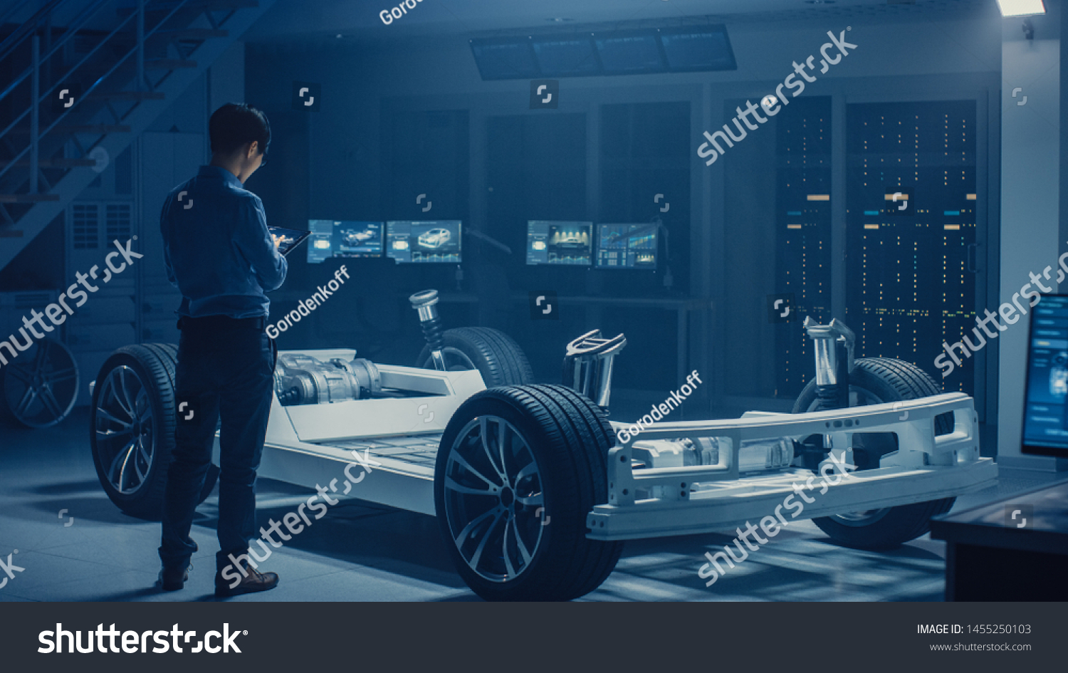 Automobile Engineer Working on Electric Car Chassis Platform, Using Tablet Computer Augmented Reality with 3D CAD Software Modelling. Innovative Facility: Vehicle Frame with Wheels, Engine, Battery #1455250103