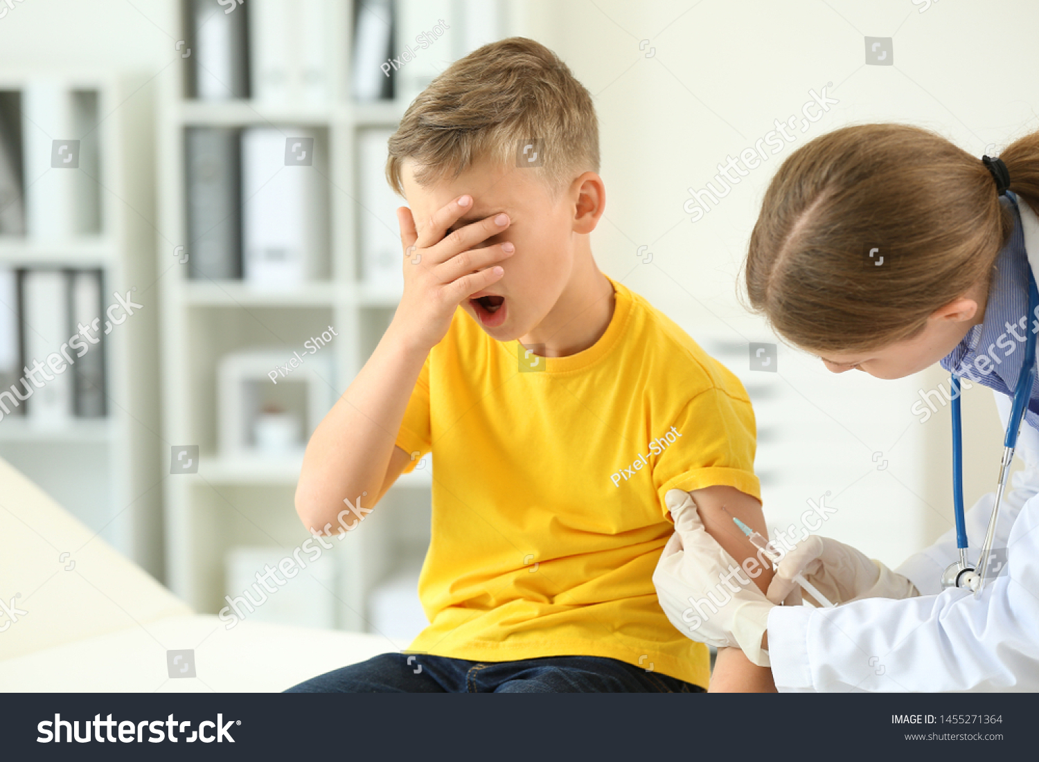 Doctor vaccinating little boy in clinic #1455271364