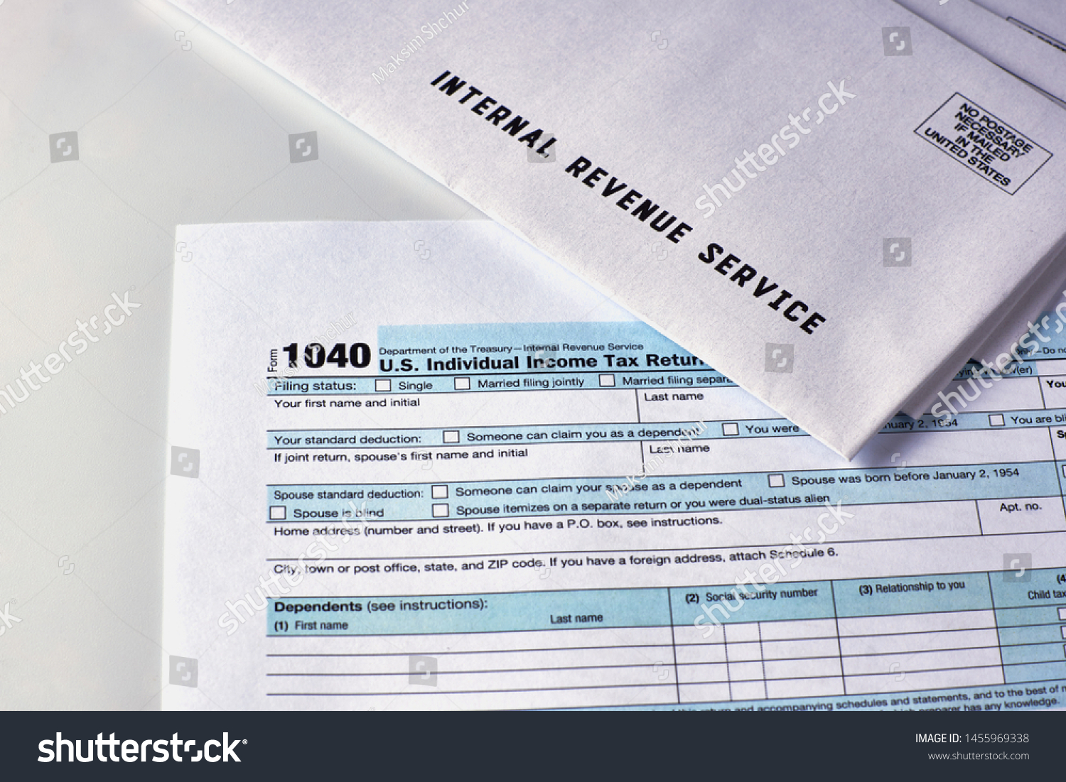 Three mails from the Internal Revenue Service lie on 1040, Schedule D form 1040 and 1040a tax forms #1455969338