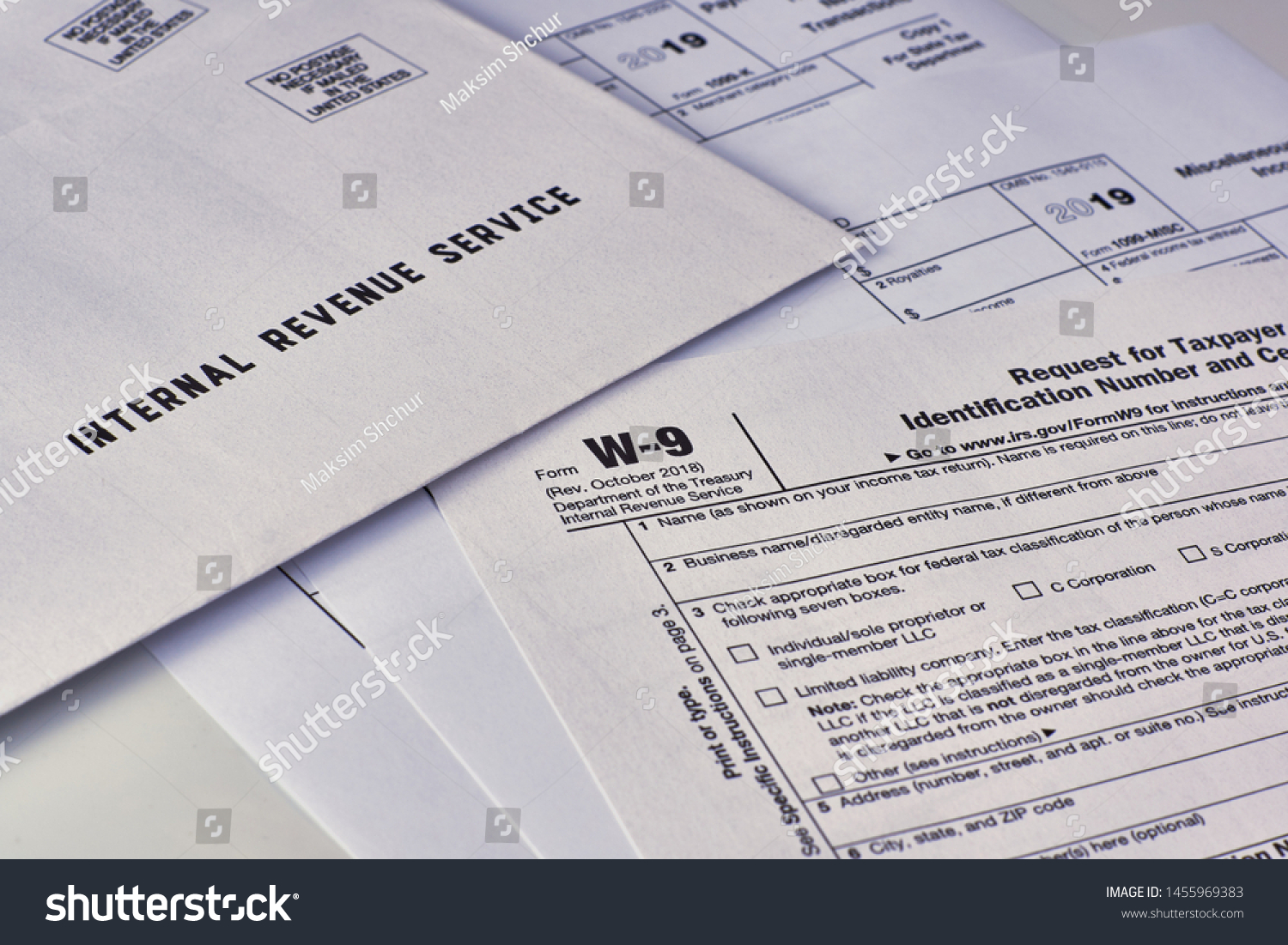 Three mails from the Internal Revenue Service lie on tax Form w-9, 1099-misc, 1099-k on a white background #1455969383