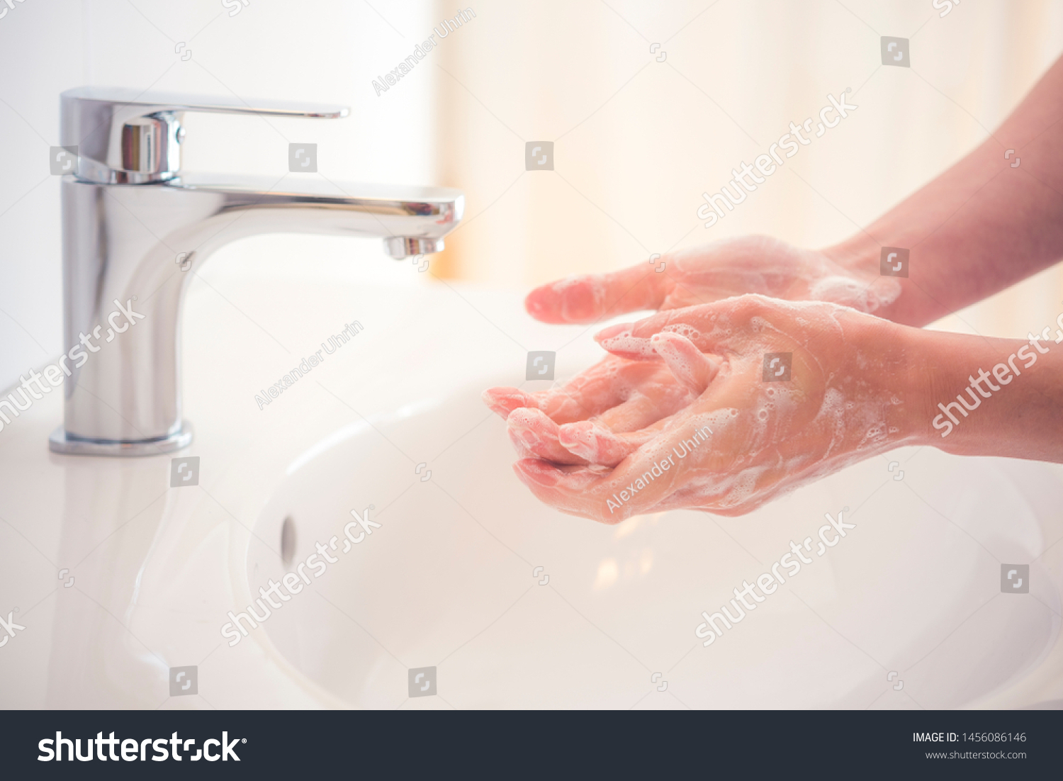 Washing hands with soap under the faucet with water. Hygiene concept. #1456086146