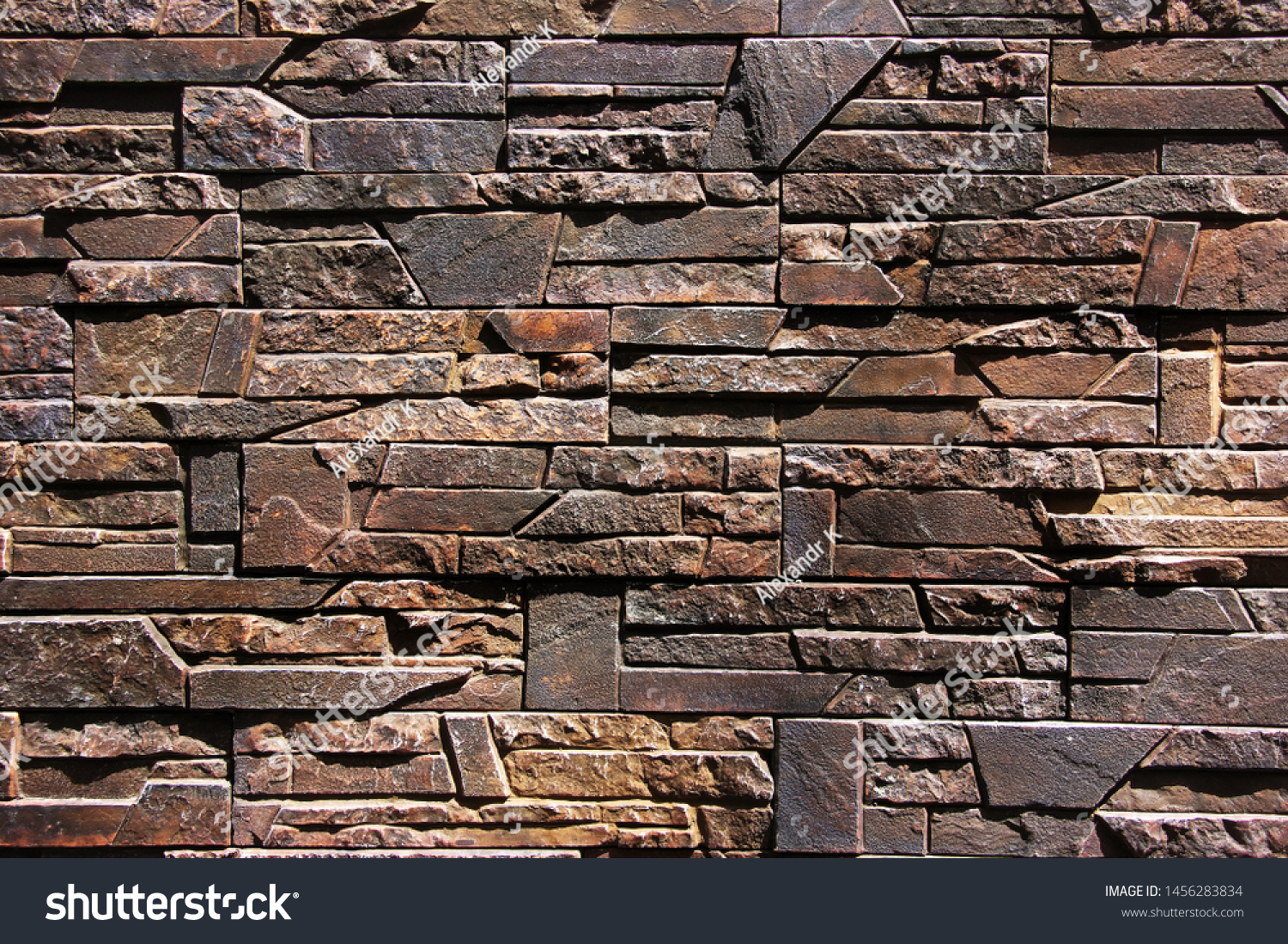 The texture of the wall is made of crushed natural stone of dark brown color. Photo for wallpaper, concept of construction and natural natural building materials. #1456283834