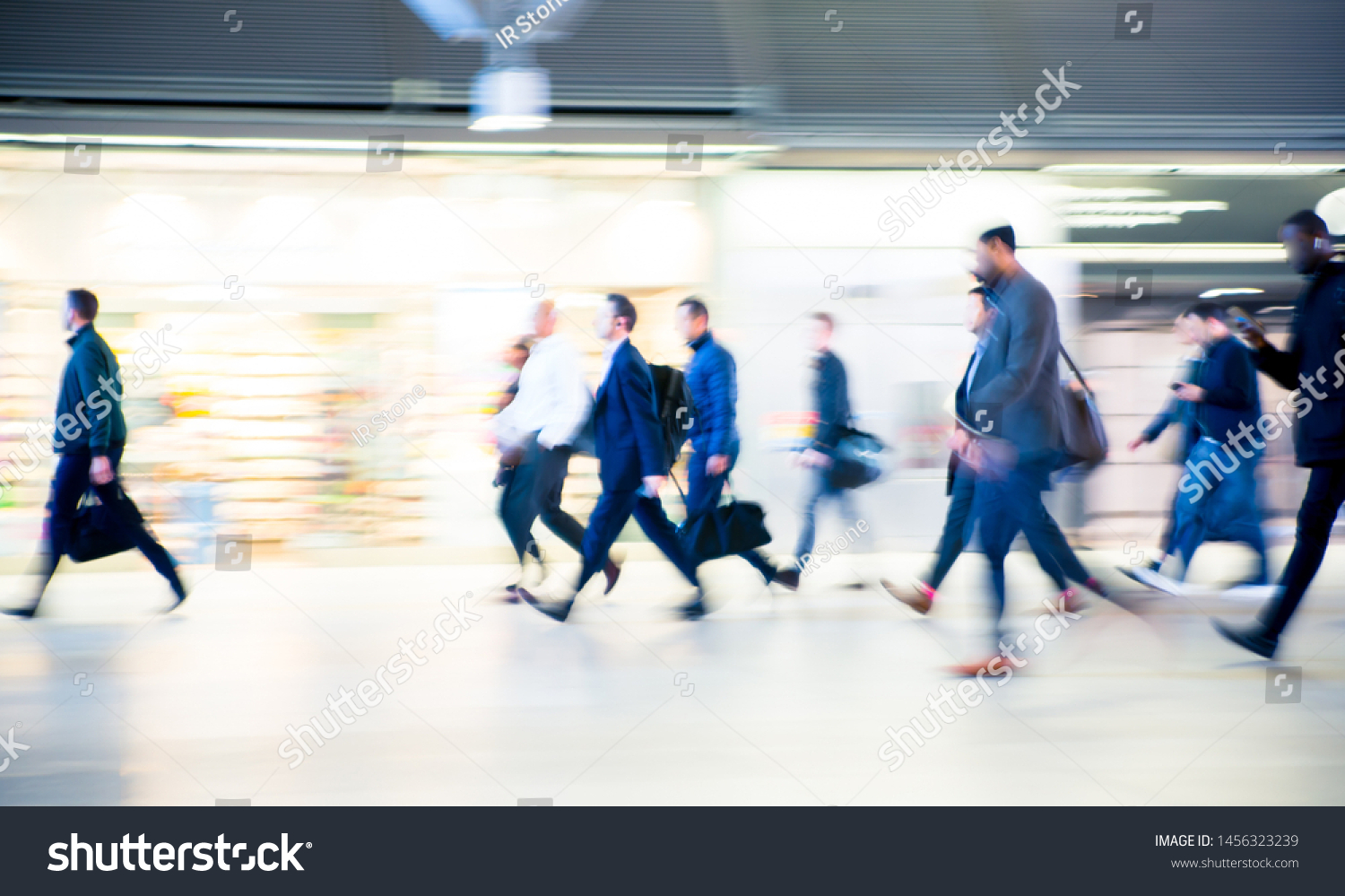 Beautiful motion blur of walking people. Early morning rush hours, busy modern life concept. Ideal for websites and magazines layouts #1456323239