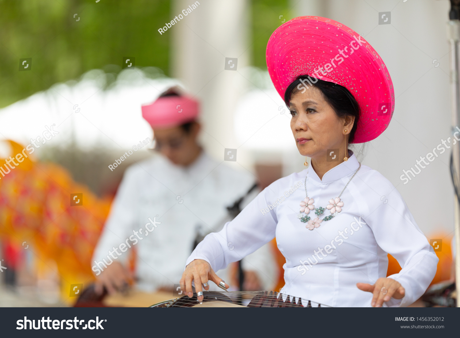 Columbus, Ohio, USA - May 26, 2019: Columbus Asian Festival, Franklin Park, vietnamese woman wearing traditional clothing playing the Dan Tranh at the asian festival #1456352012