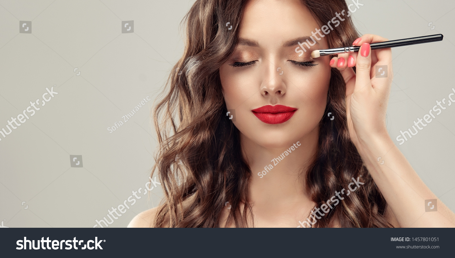  Makeup artist applies  eye shadow  . Beautiful woman face. Hand of visagiste, painting  cosmetics of young beauty  model girl . Make up in process #1457801051