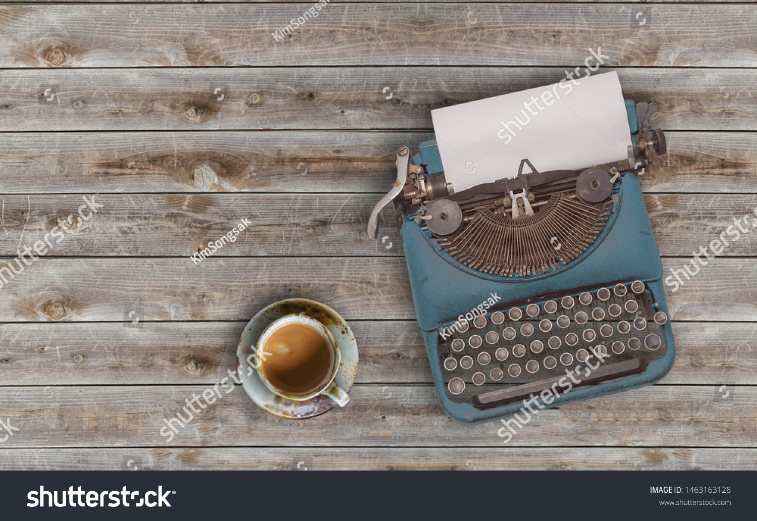 top view photo of vintage typewriter with blank page next to cup of coffee, on wooden table. #1463163128