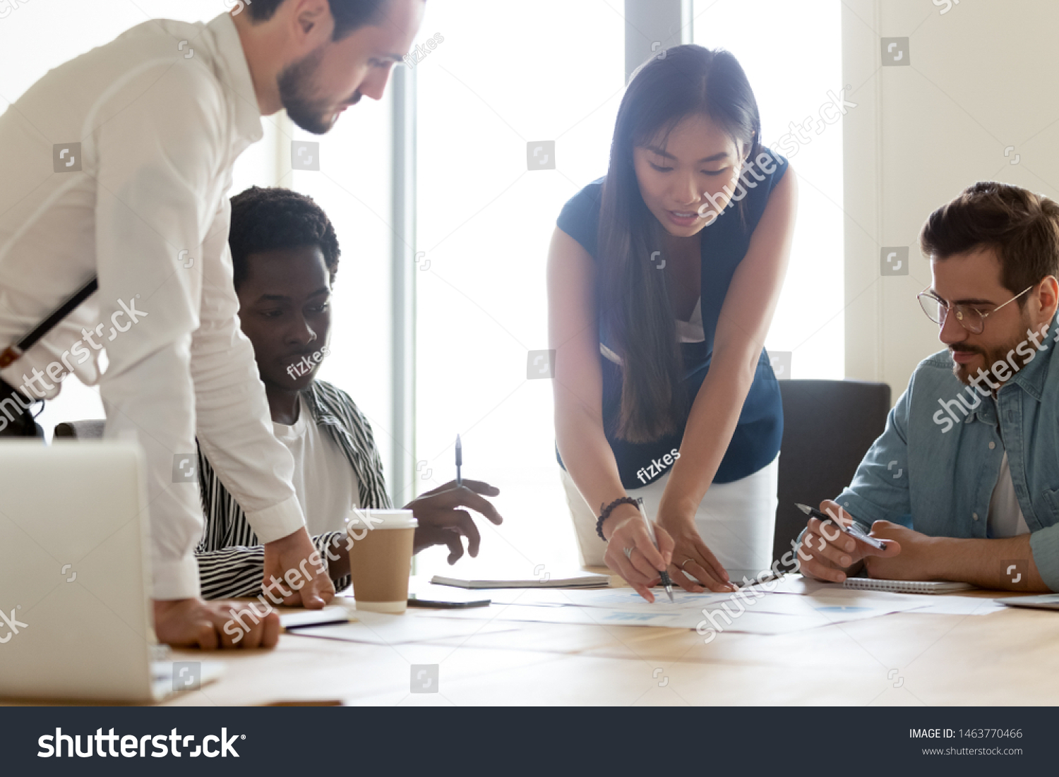 Focused diverse business executive team people designers architects with female asian leader manager discuss paperwork financial report brainstorm work together at group corporate office meeting #1463770466
