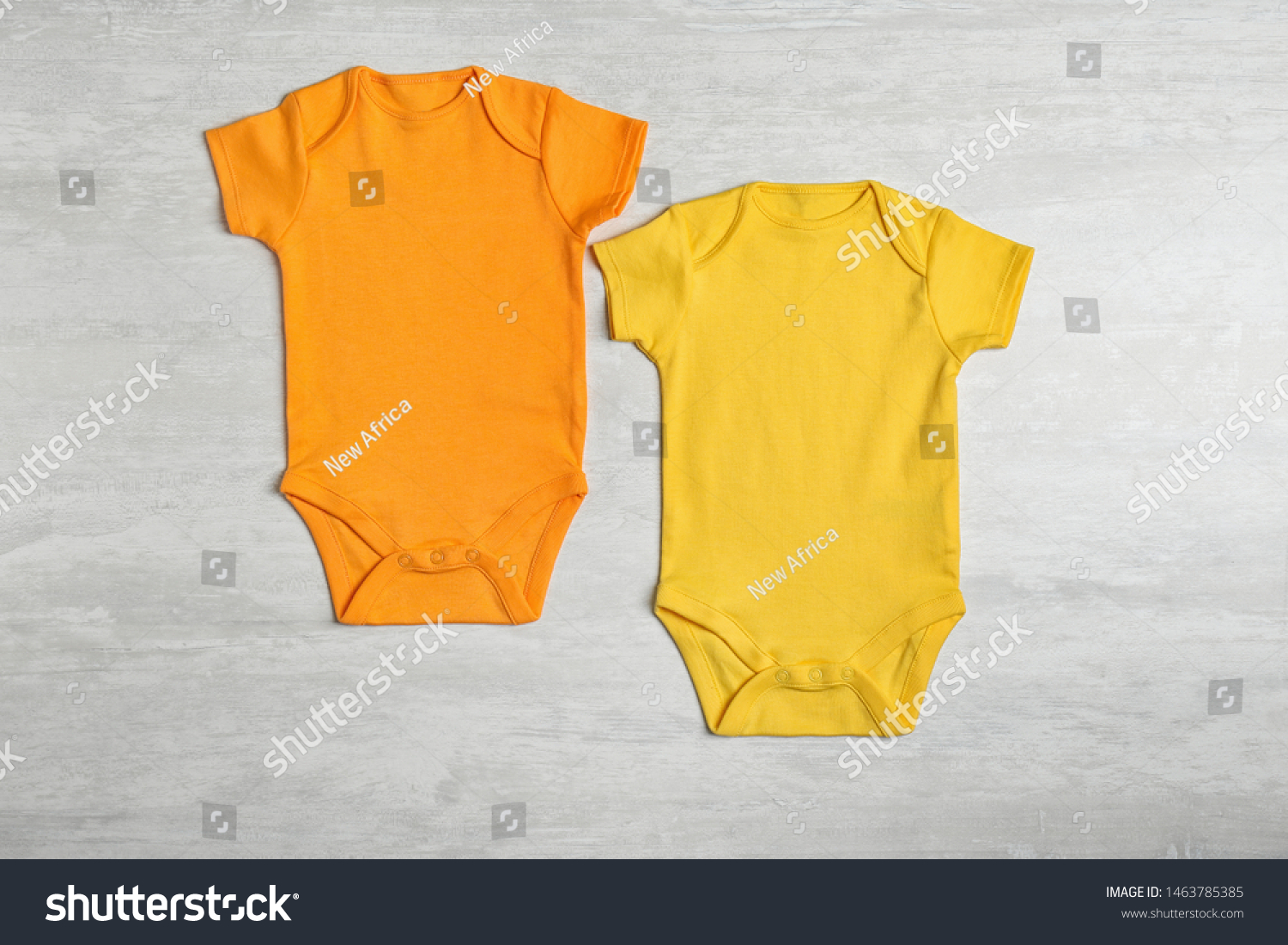 Different baby bodysuits on wooden background, top view #1463785385