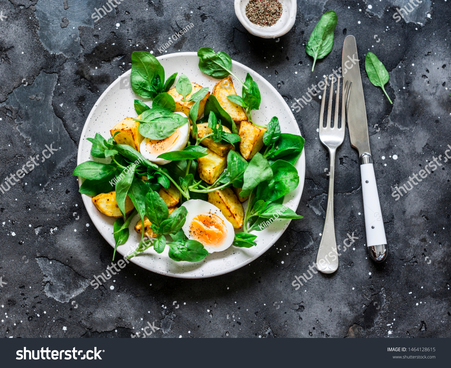 Baked potato, boiled egg and spinach salad on dark background, top view #1464128615