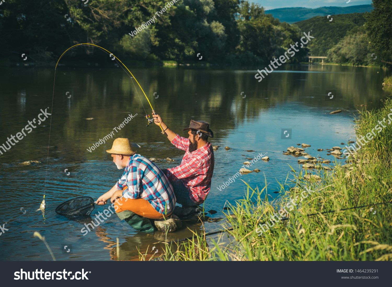 Man fisherman catches a fish. Fly fishing is most renowned as a method for catching trout grayling and salmon #1464239291