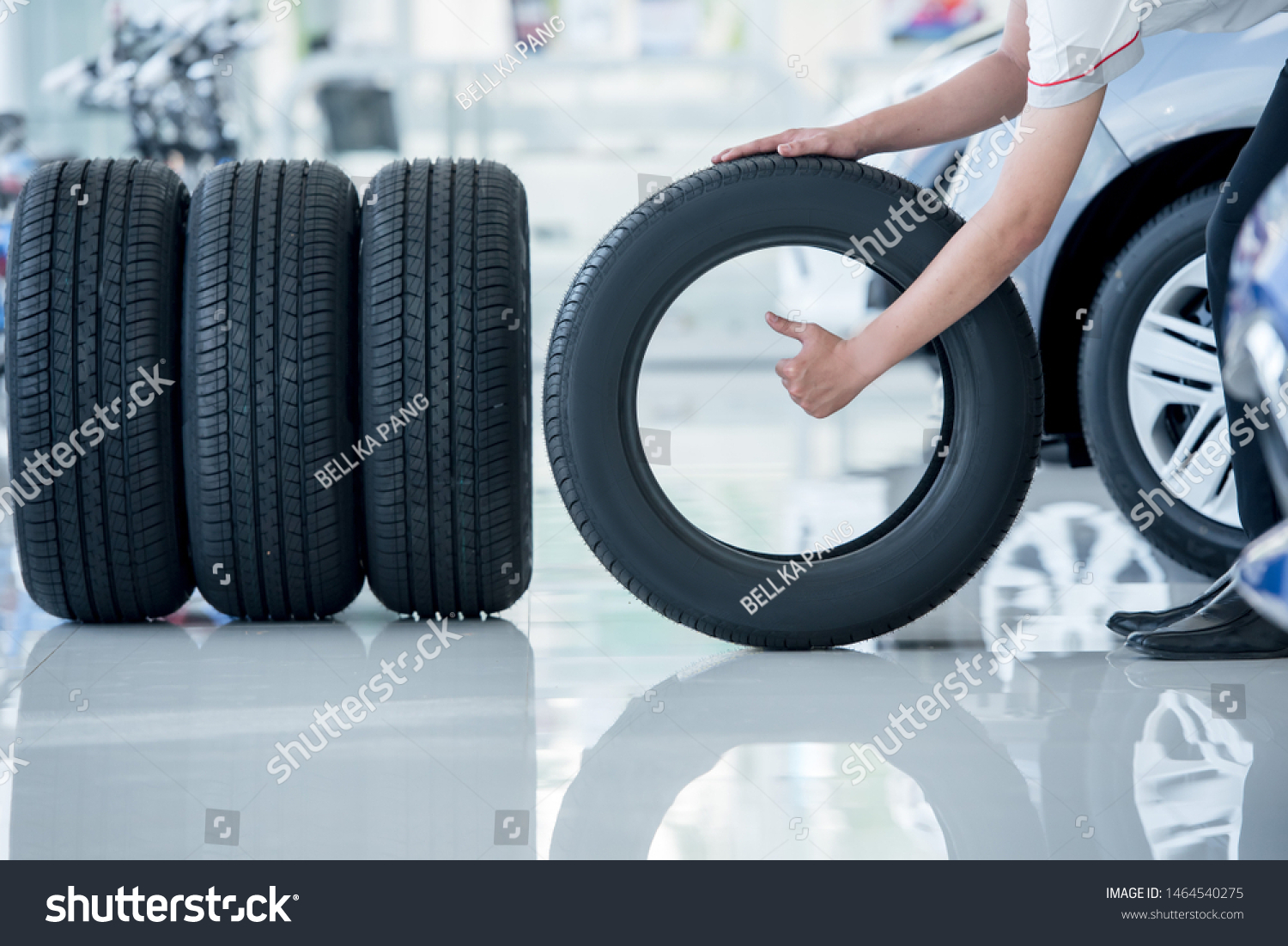 4 new tires that change tires in the auto repair service center, blurred background, the background is a new car in the stock blur for the industry, a four-wheeled tire set at a large warehouse #1464540275