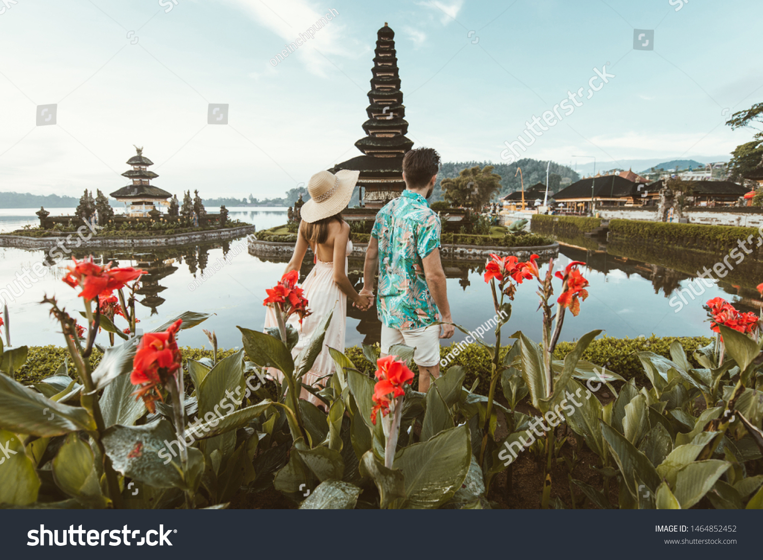 Couple at the Pura Ulun Danu Bratan, Bali. Hindu temple surrounded by flowers on Bratan lake, Bali. #1464852452