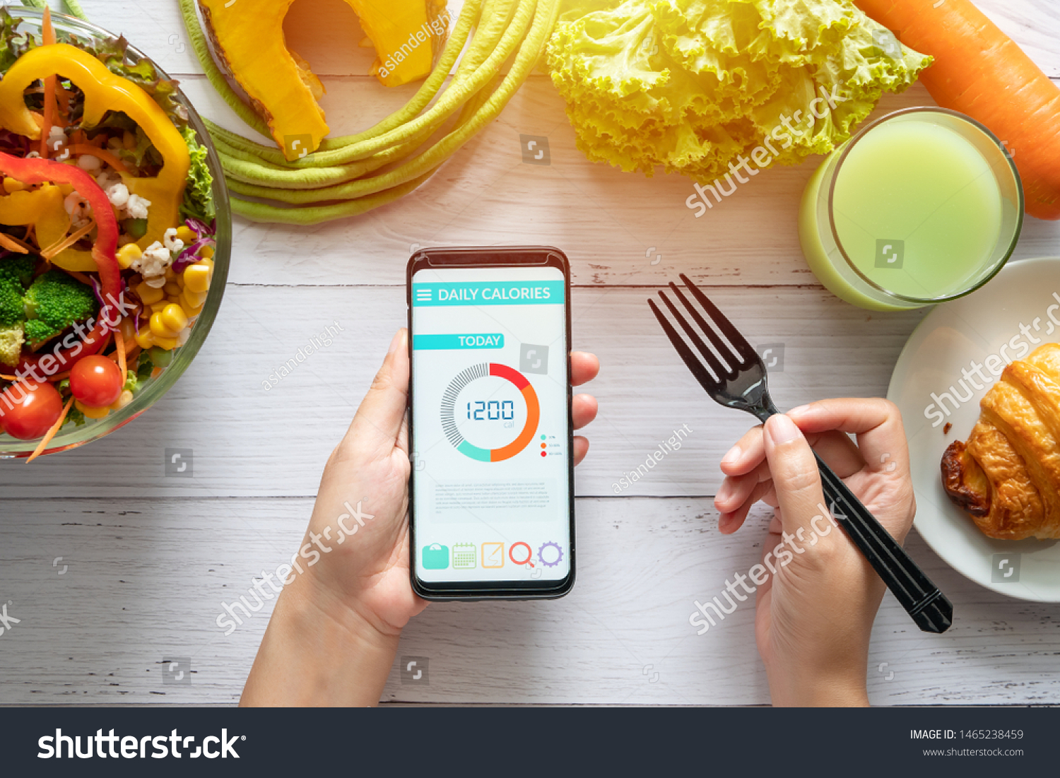 Calories counting , diet , food control and weight loss concept. woman using Calorie counter application on her smartphone at dining table with salad, fruit juice, bread and vegetable #1465238459