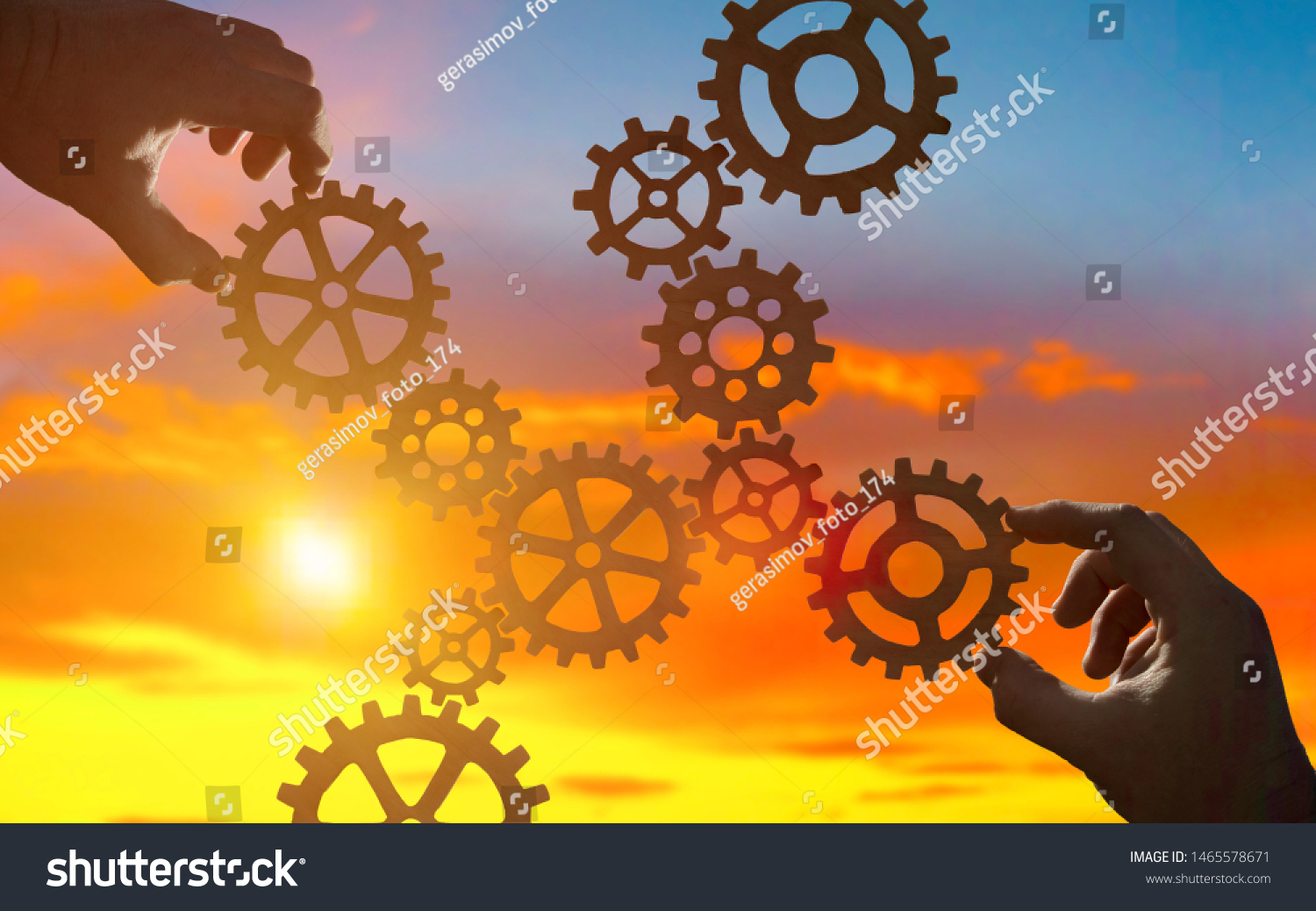 Hands collect gear in a puzzle against the sky in the sunset. Business concept idea, partnership, innovation, teamwork, cooperation #1465578671
