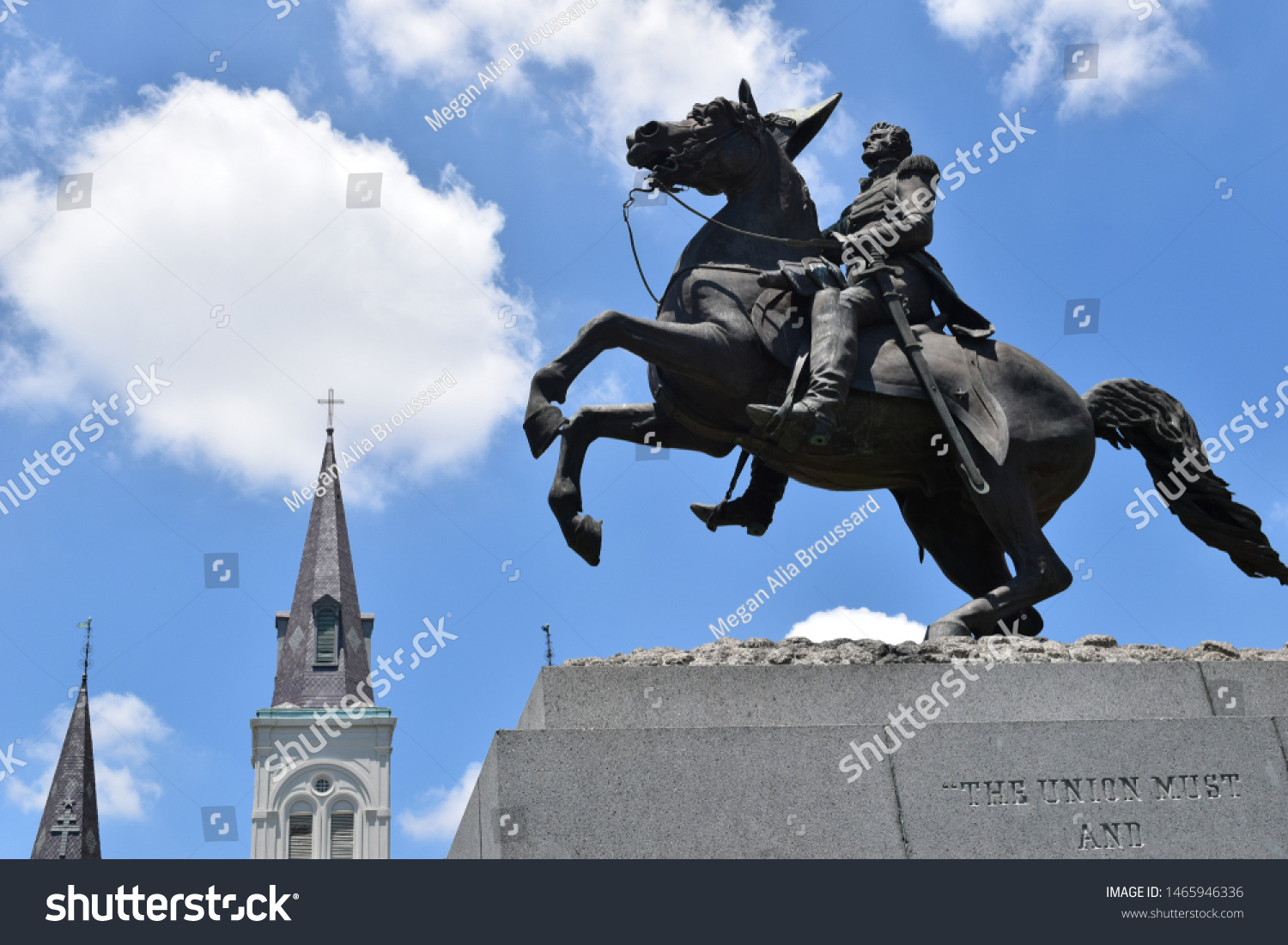 Jackson Square New Orleans Louisiana Statue of Andrew Jackson on horse with with St. Louis Cathedral’s steeples and bright blue sky with clouds in background #1465946336