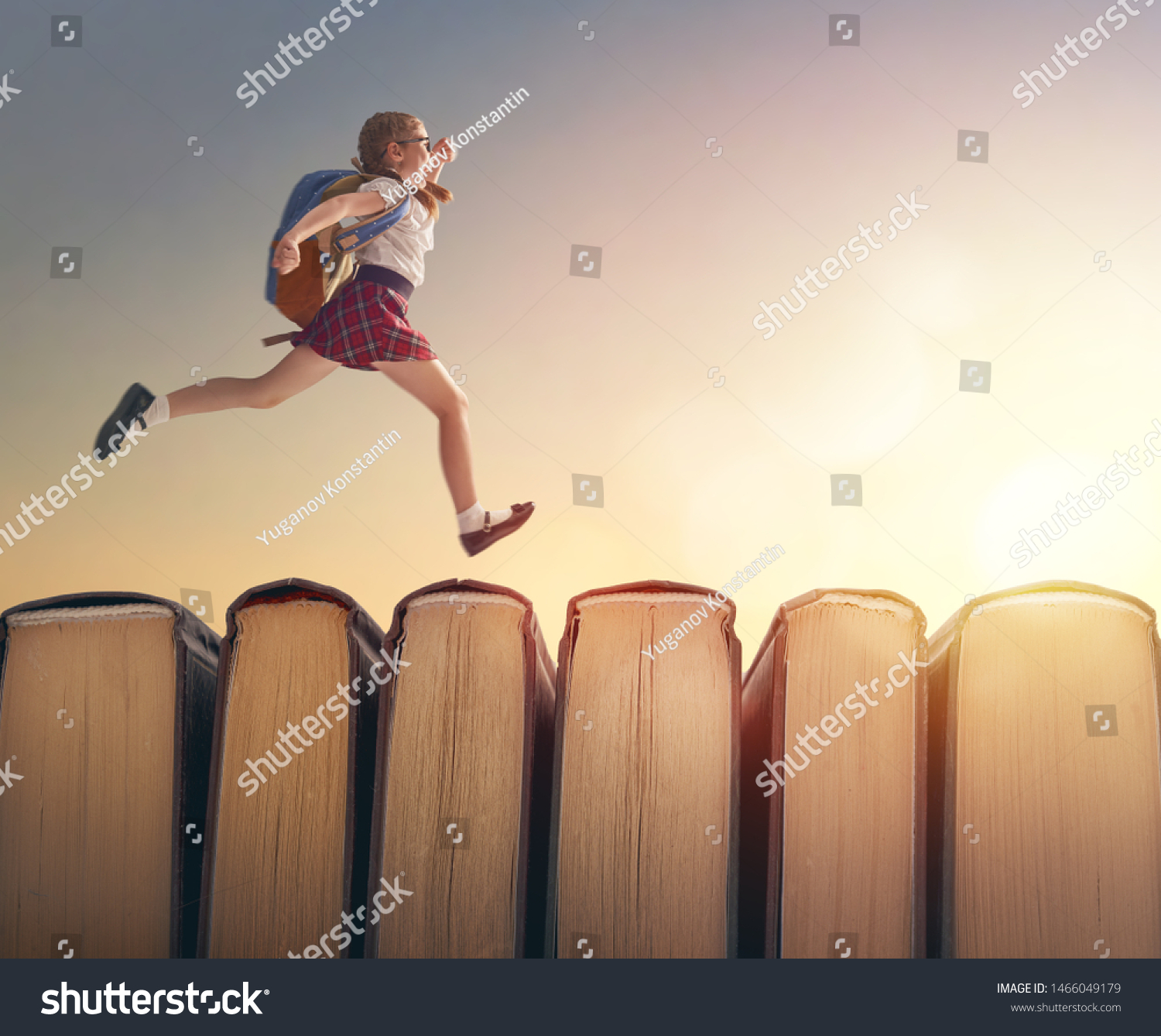 Back to school! Happy cute industrious child are running on books on background of sunset landscape. Concept of education and reading. The development of the imagination.                               #1466049179