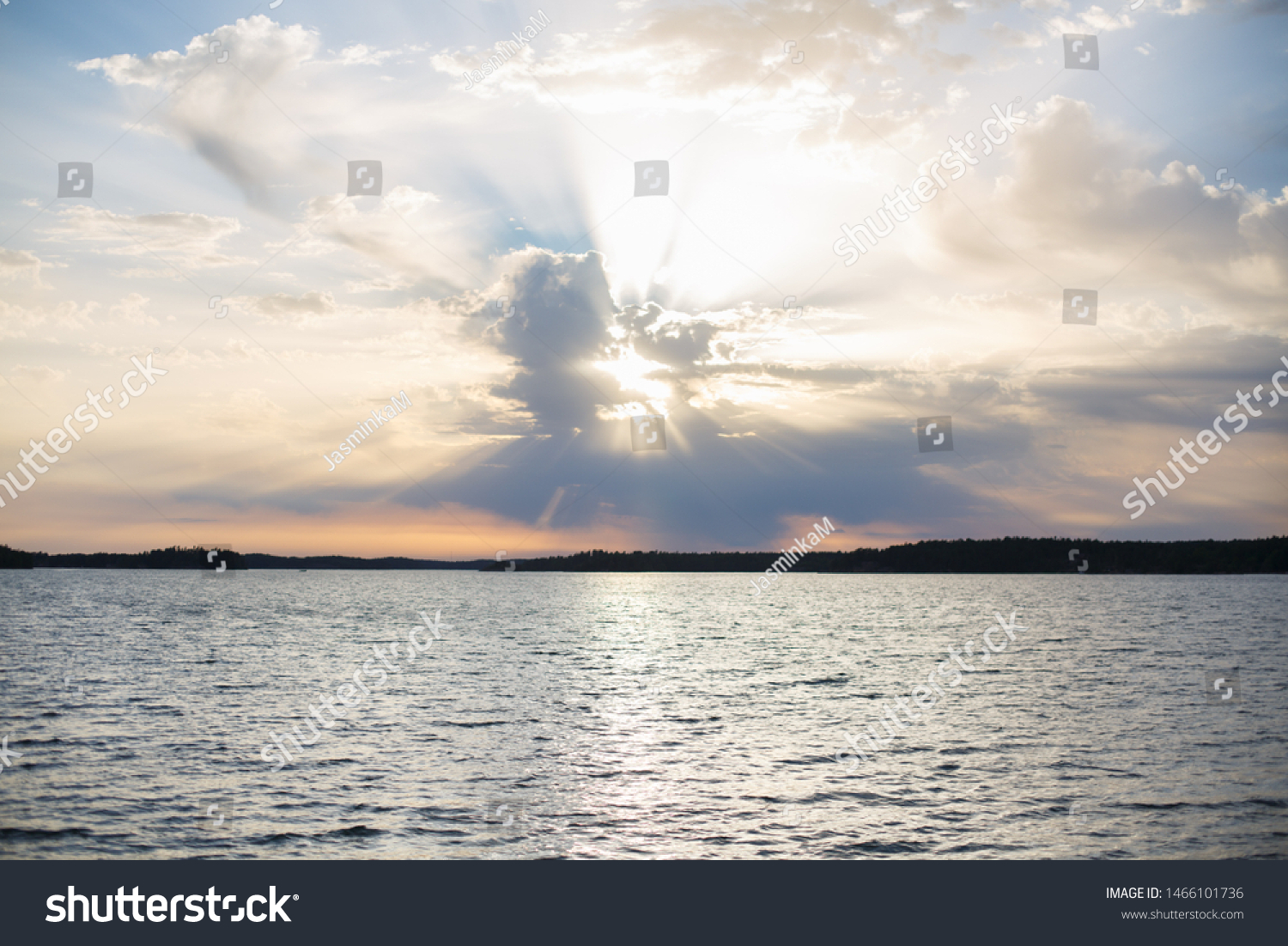 Beautiful sunset above a river or sea. Fantastic sky with sun rays. Sun rays from clouds.  #1466101736