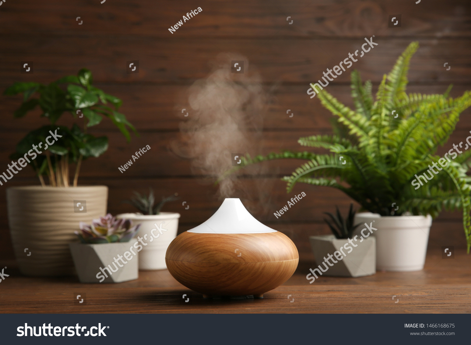 Composition with modern essential oil diffuser on wooden table against brown background, space for text #1466168675