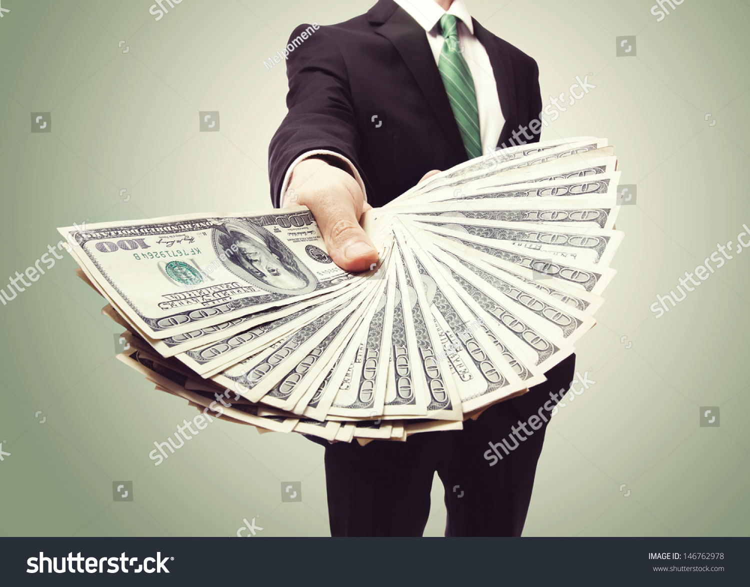 Business Man Displaying a Spread of Cash over a green vintage background #146762978