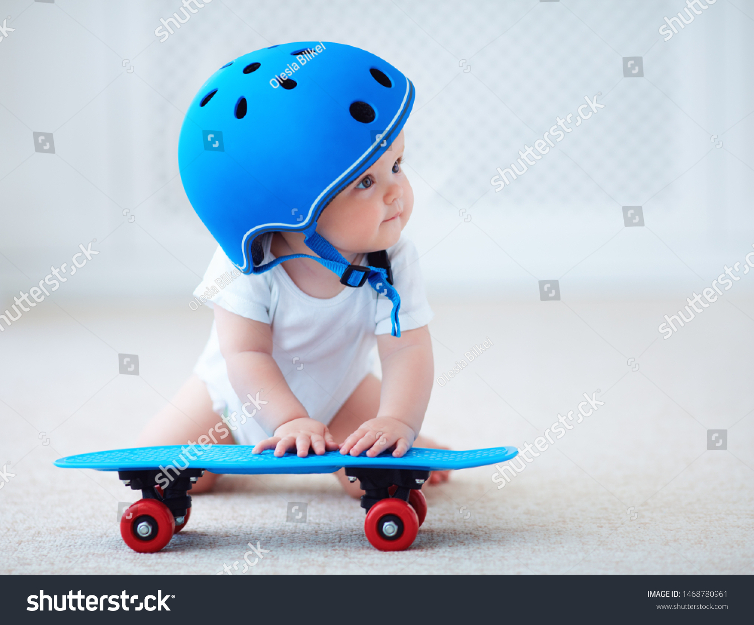 cute infant baby girl in protective helmet outfit ready to ride skateboard, extreme sport concept #1468780961