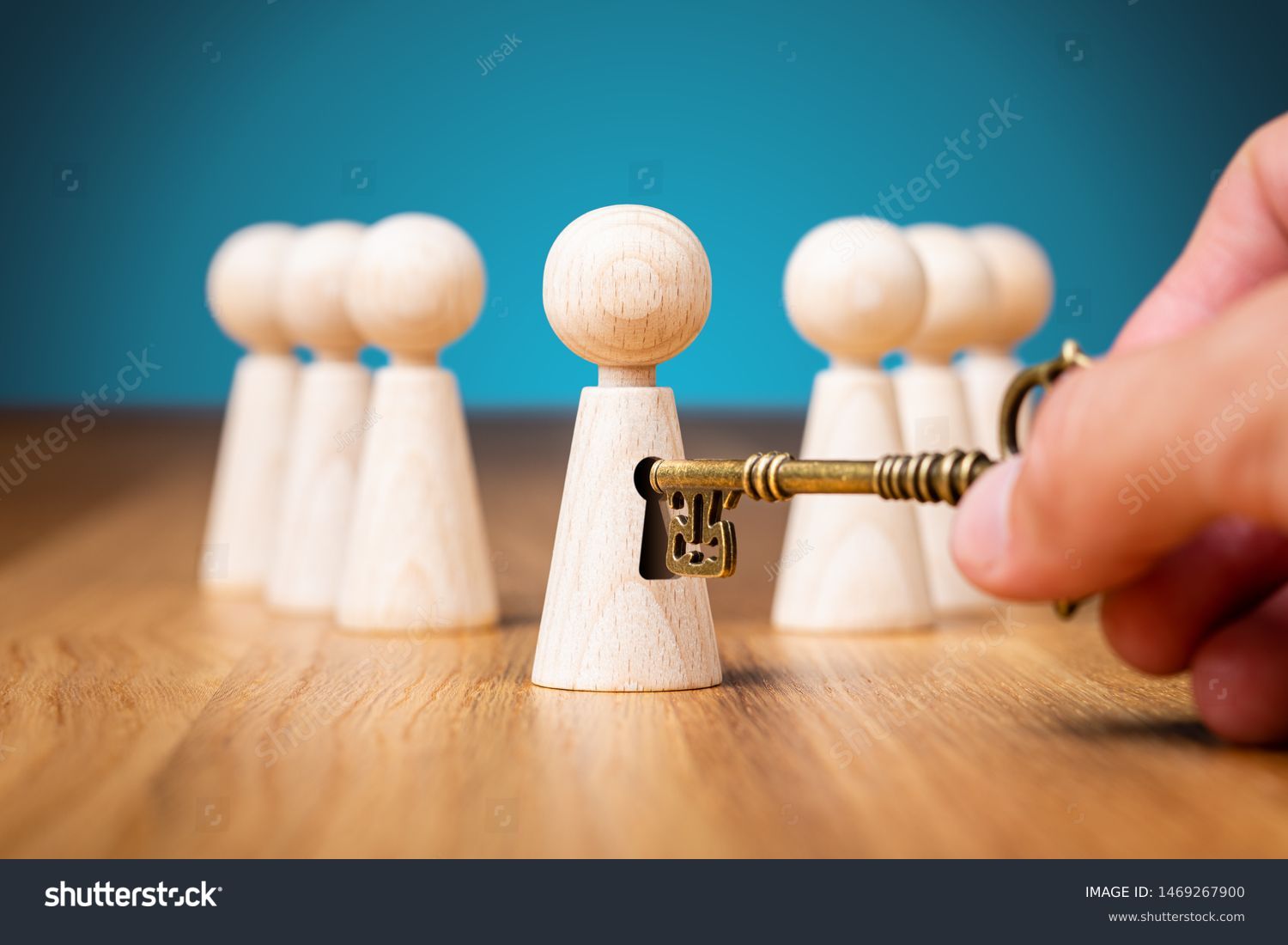 Coach unlock potential - motivation concept. Coach (manager, mentor, HR specialist) unlock leader potential and talent represented by wooden figurine and hand with key. #1469267900