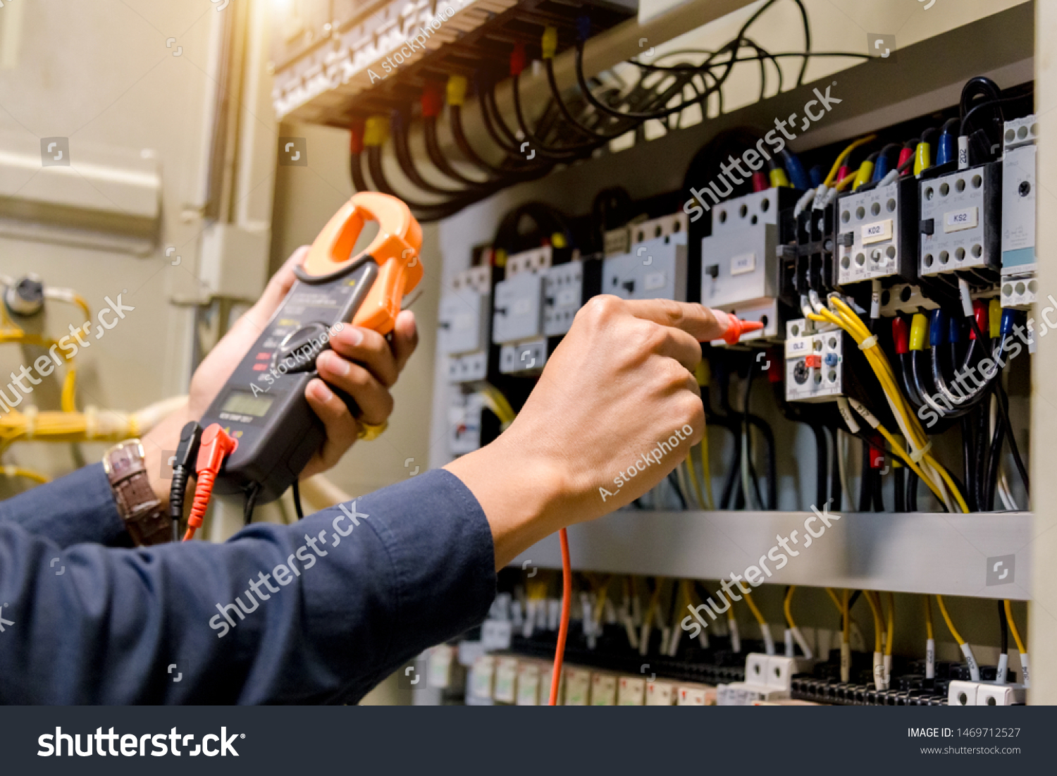 Electrician engineer work  tester measuring  voltage and current of power electric line in electical cabinet control. #1469712527