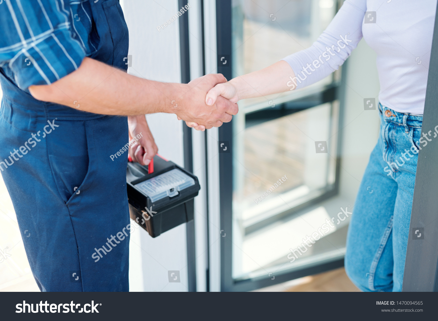 Young woman and technician saying goodbye while shaking hands after repair work #1470094565