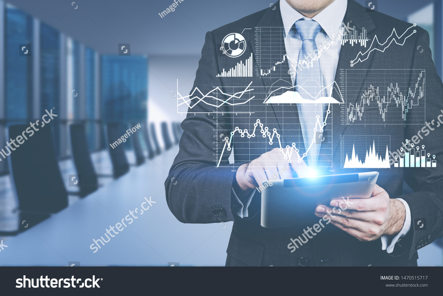Businessman using tablet computer in blurred meeting room with double exposure of graphs and business infographics. Concept of trading and market analysis. Toned image #1470515717