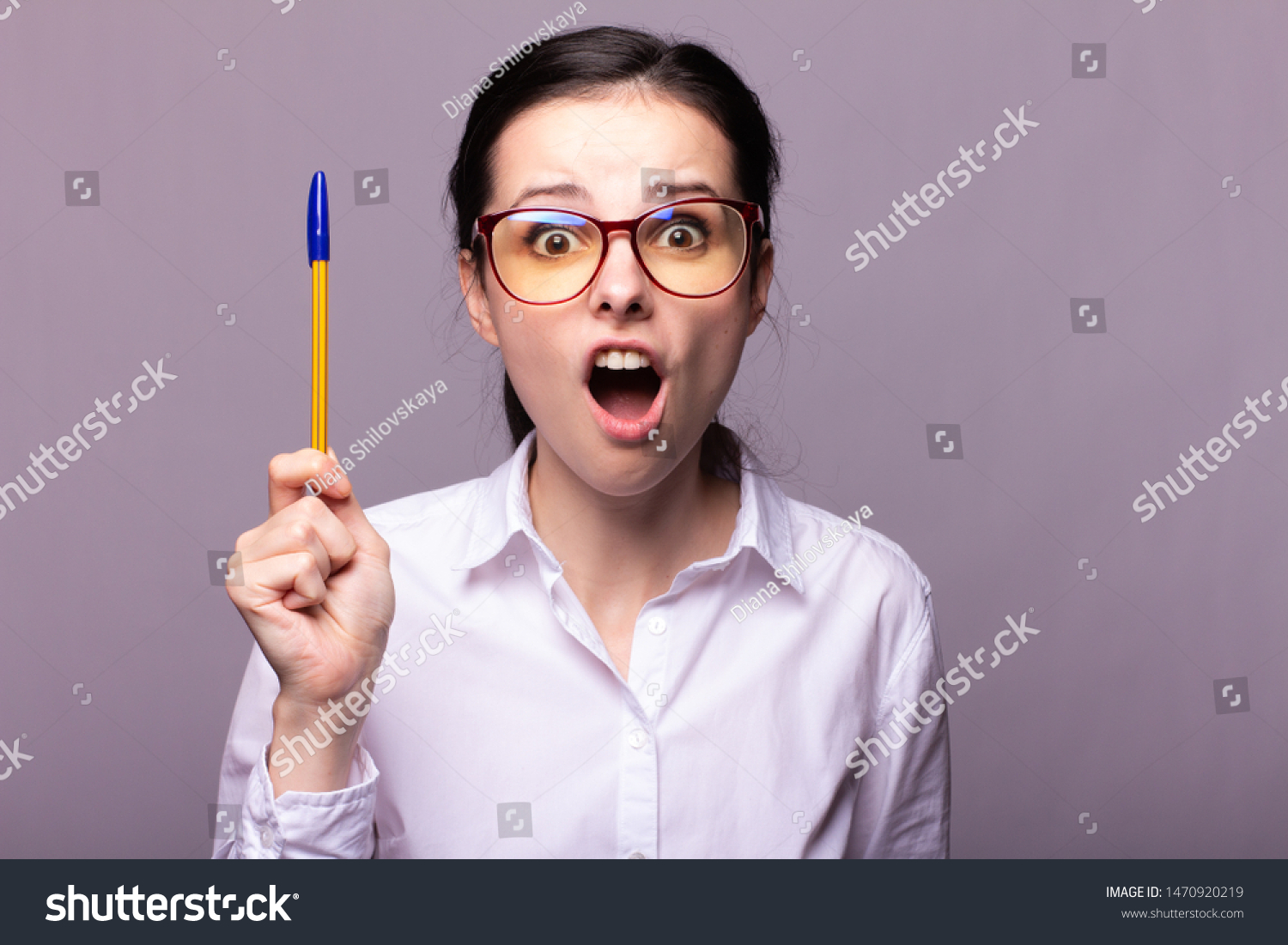 
girl in a white shirt and glasses holds a pen in her hand #1470920219