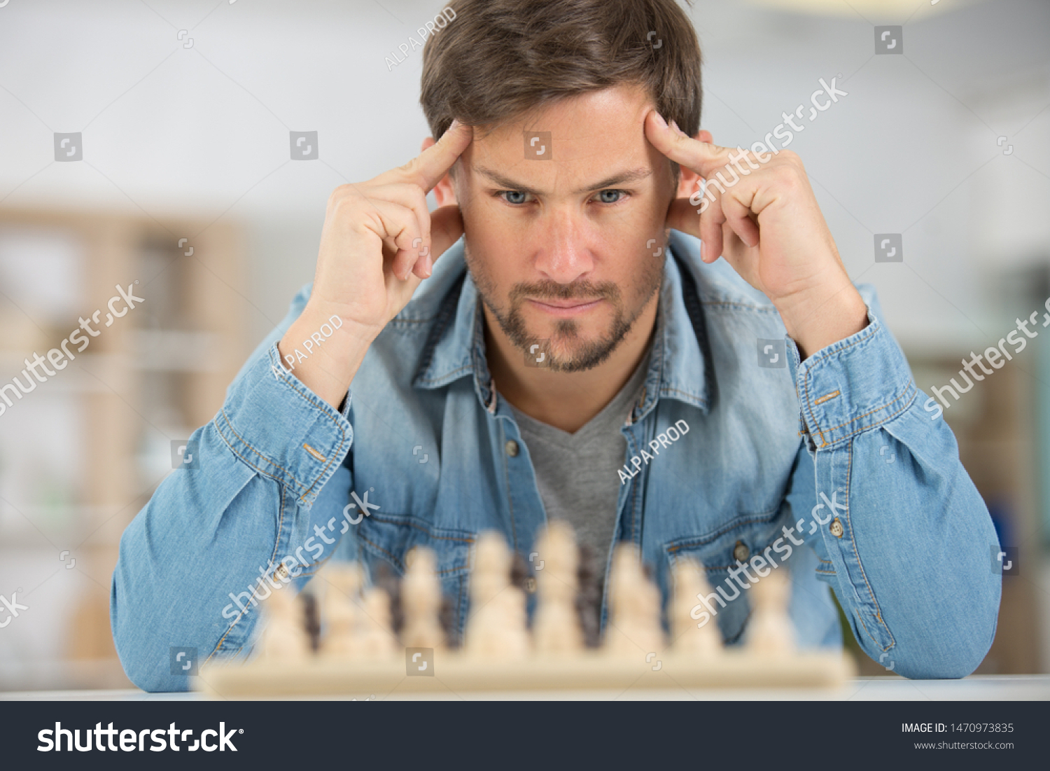 young man concentrating on a chess game #1470973835