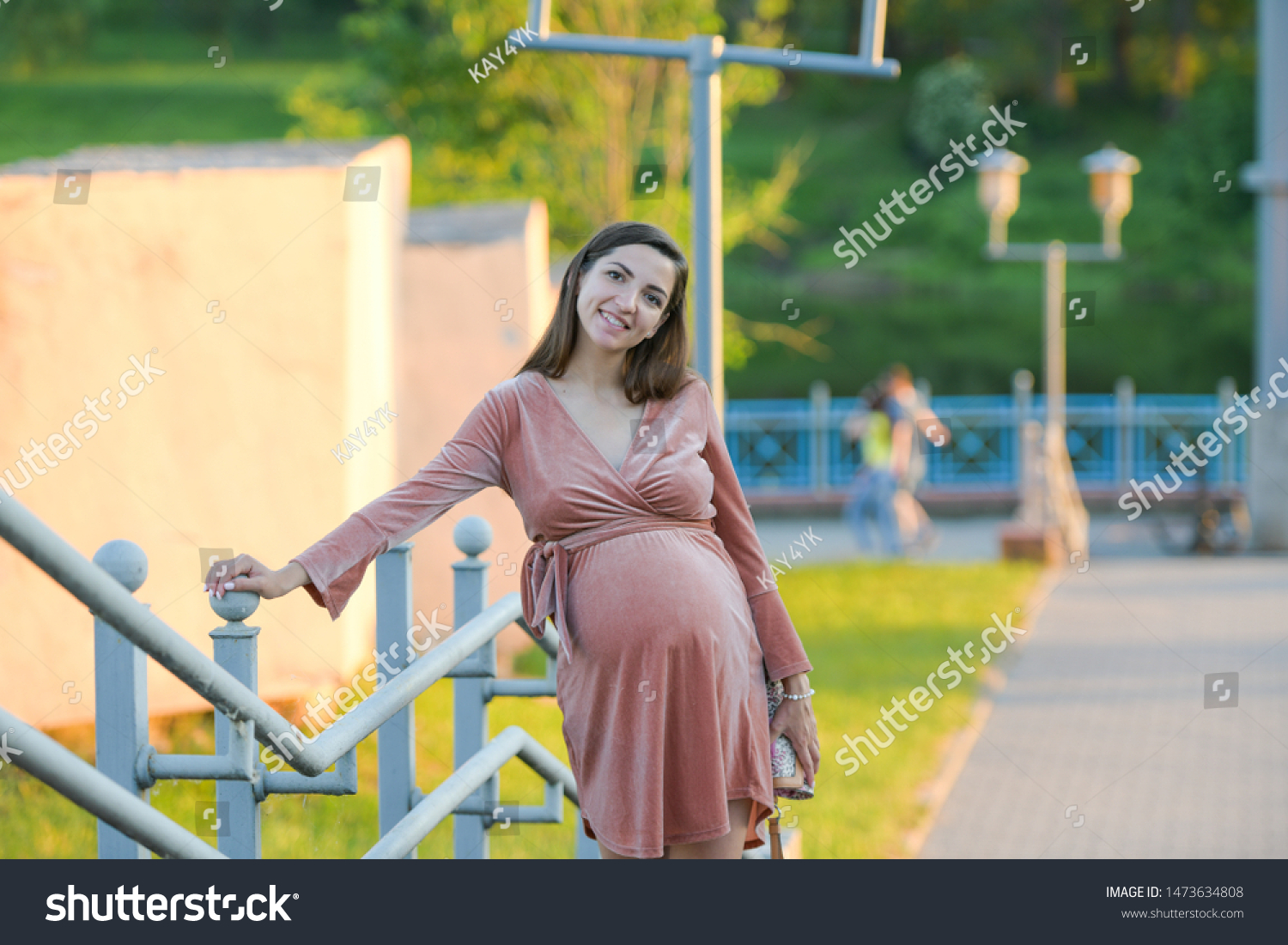 Girl posing on the promenade. A girl walks along the promenade. A young girl walks past the fence #1473634808