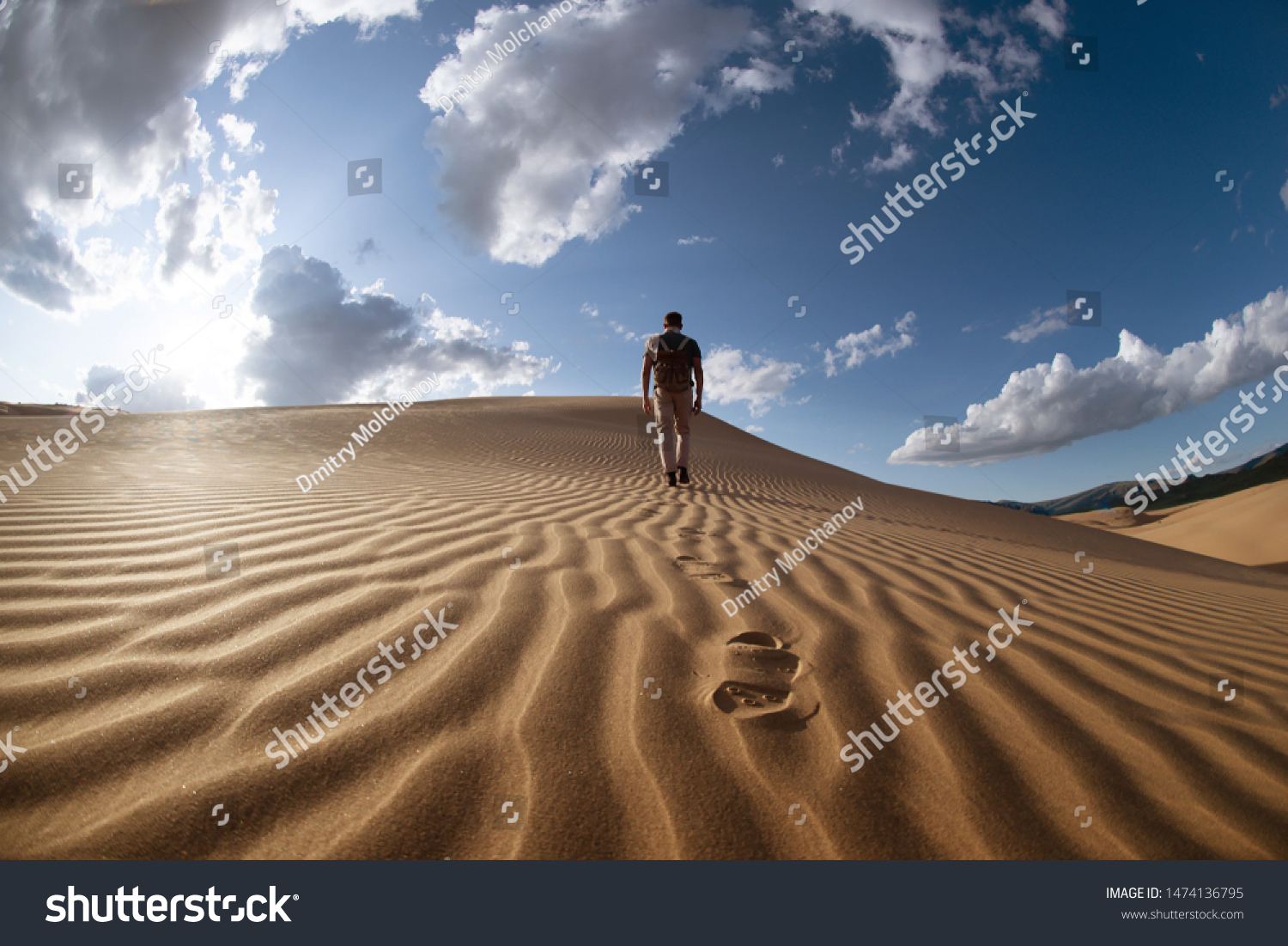 One lonely man walks in desert on dunes #1474136795