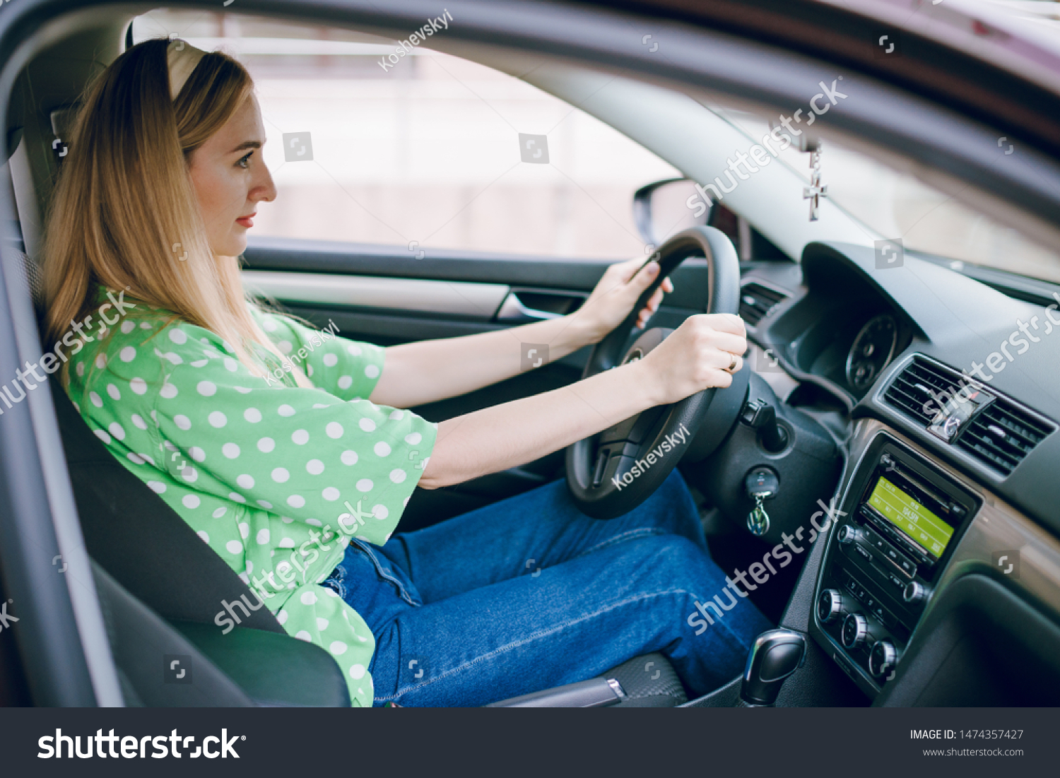 Beautiful blonde girl sitting in the car driving listening to music and drinking coffee #1474357427