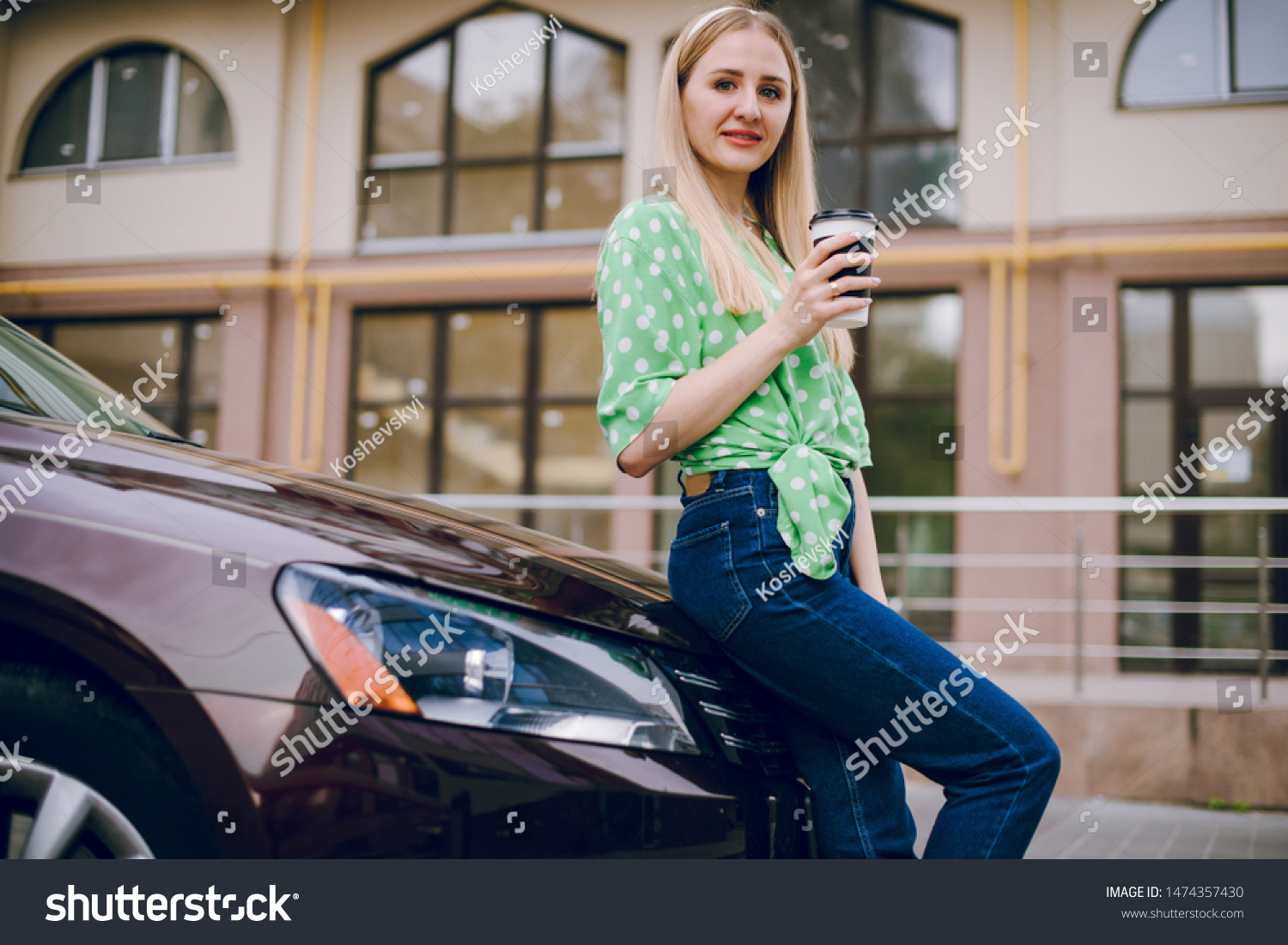 Beautiful blonde girl sitting in the car driving listening to music and drinking coffee #1474357430