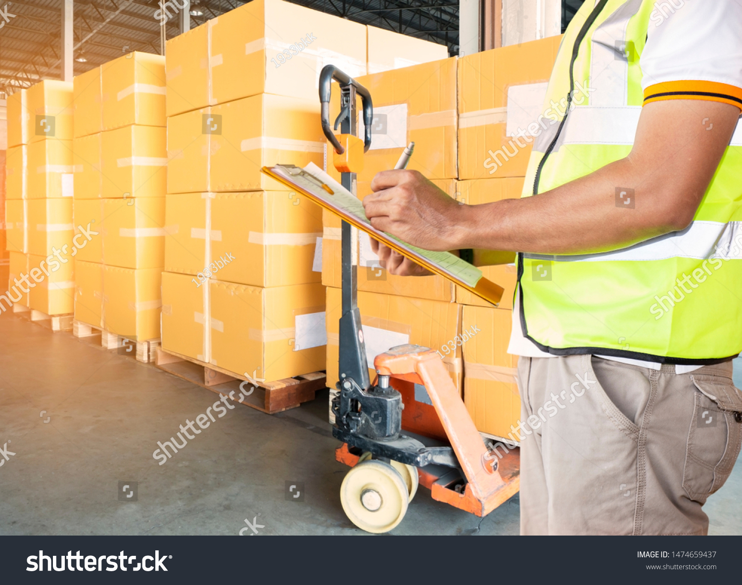 Warehouse Cargo Courier Shipping and  Transportation, Stack cardboard boxes on pallet, worker man hand holding clipboard with inventory management products at distribution warehouse. #1474659437