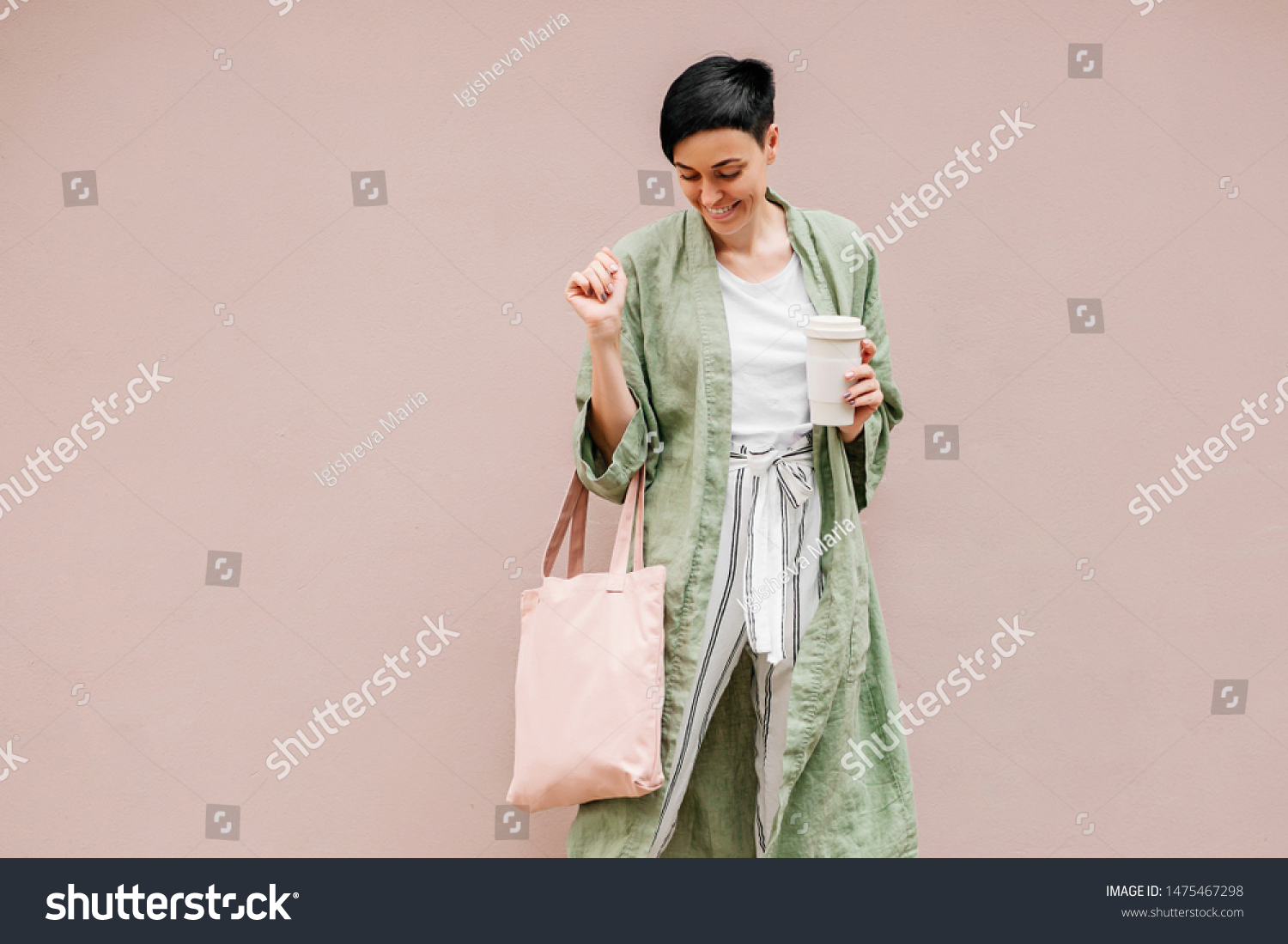 Woman with short hair holding reusable coffee cup and eco bag enjoying morning. Eco friendly concept. #1475467298