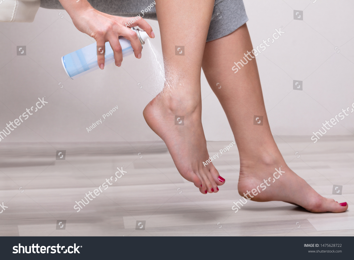 Low Section Of Woman's Hand Spraying Relief Spray On Her Foot At Home #1475628722