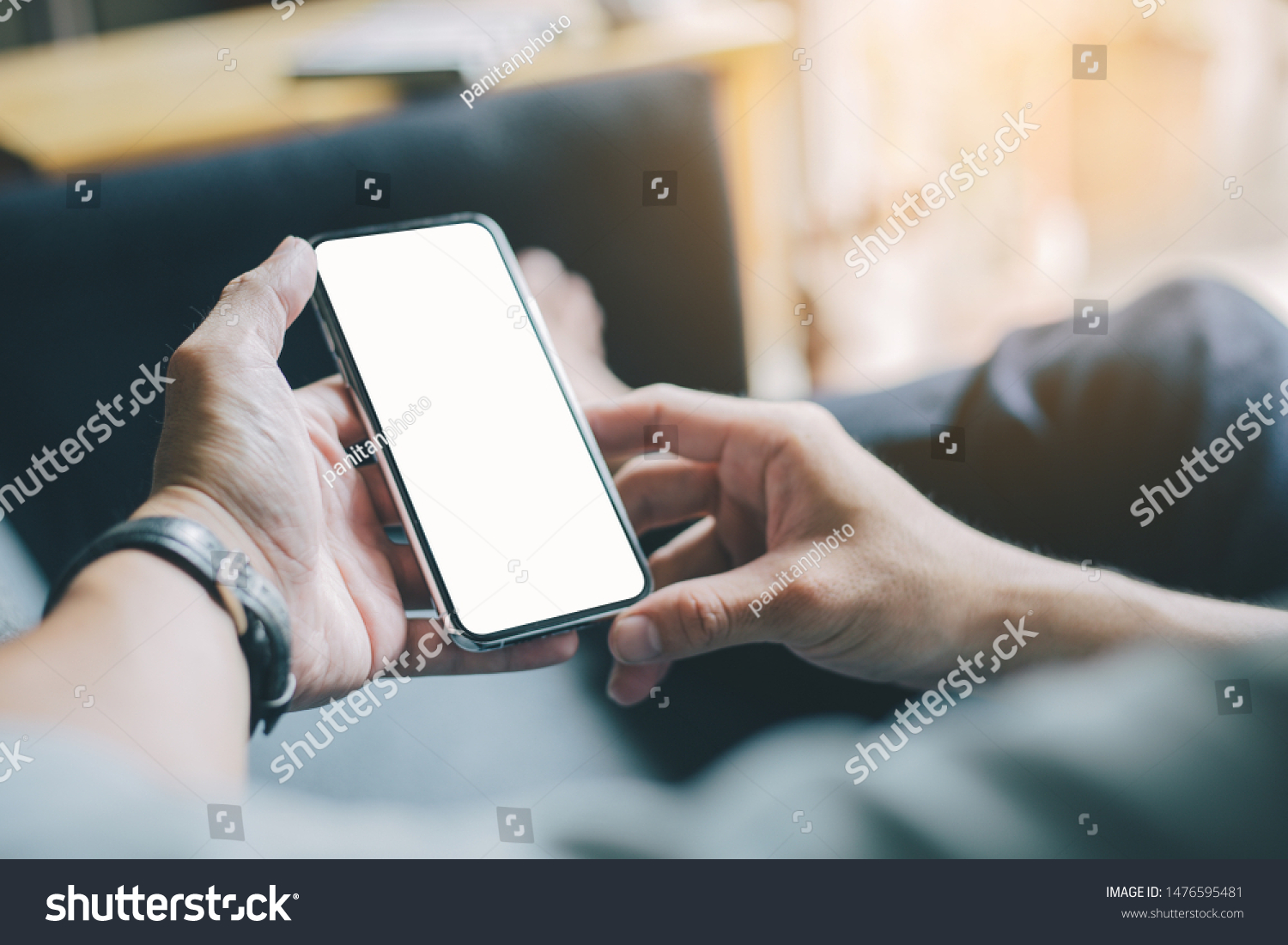Mockup image screen cell phone.men hand holding texting using mobile at sofa.with white blank space for advertise text.concept for contact business,people communication,technology device #1476595481