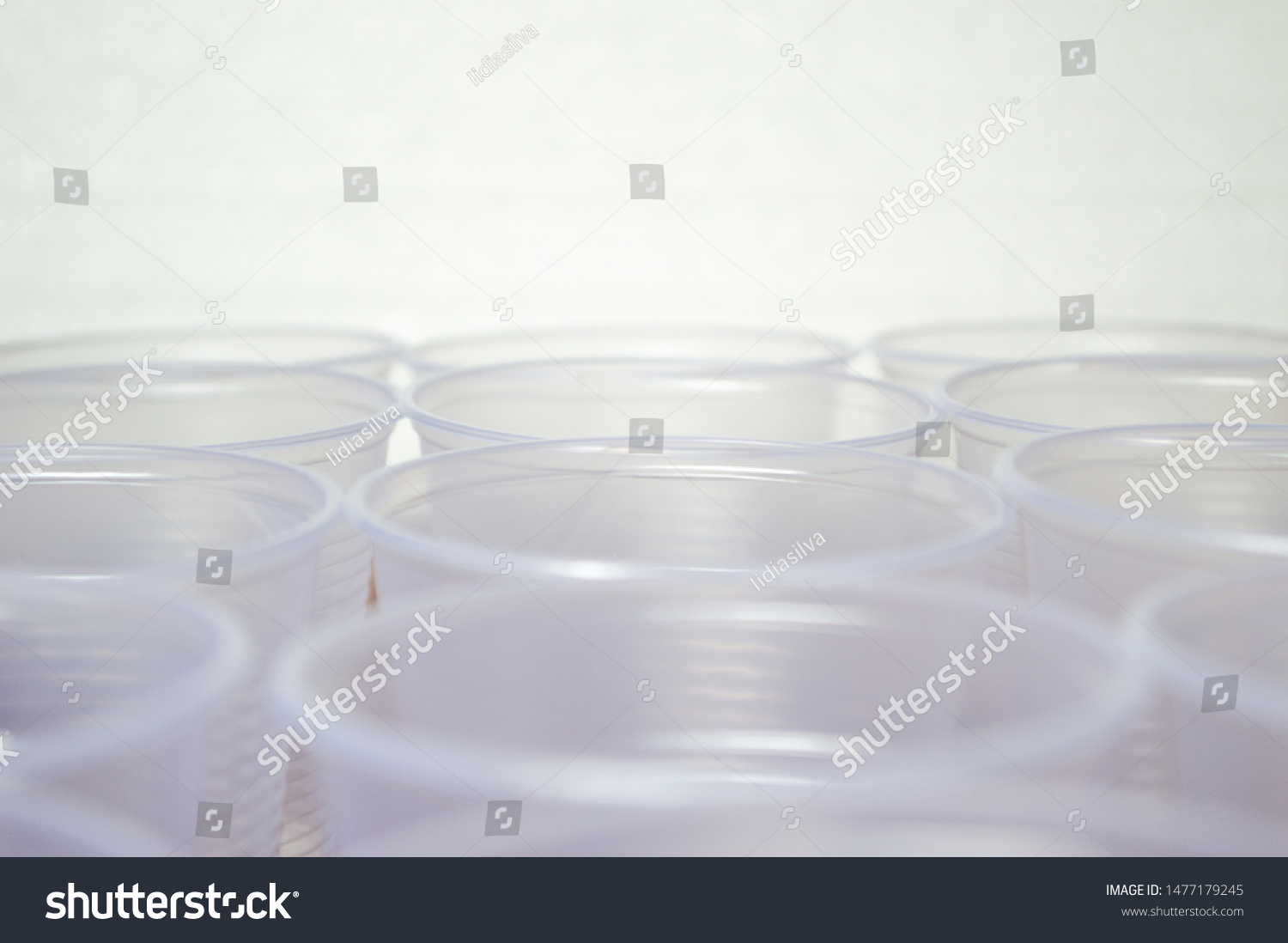 transparent disposable plastic cups on wooden table #1477179245