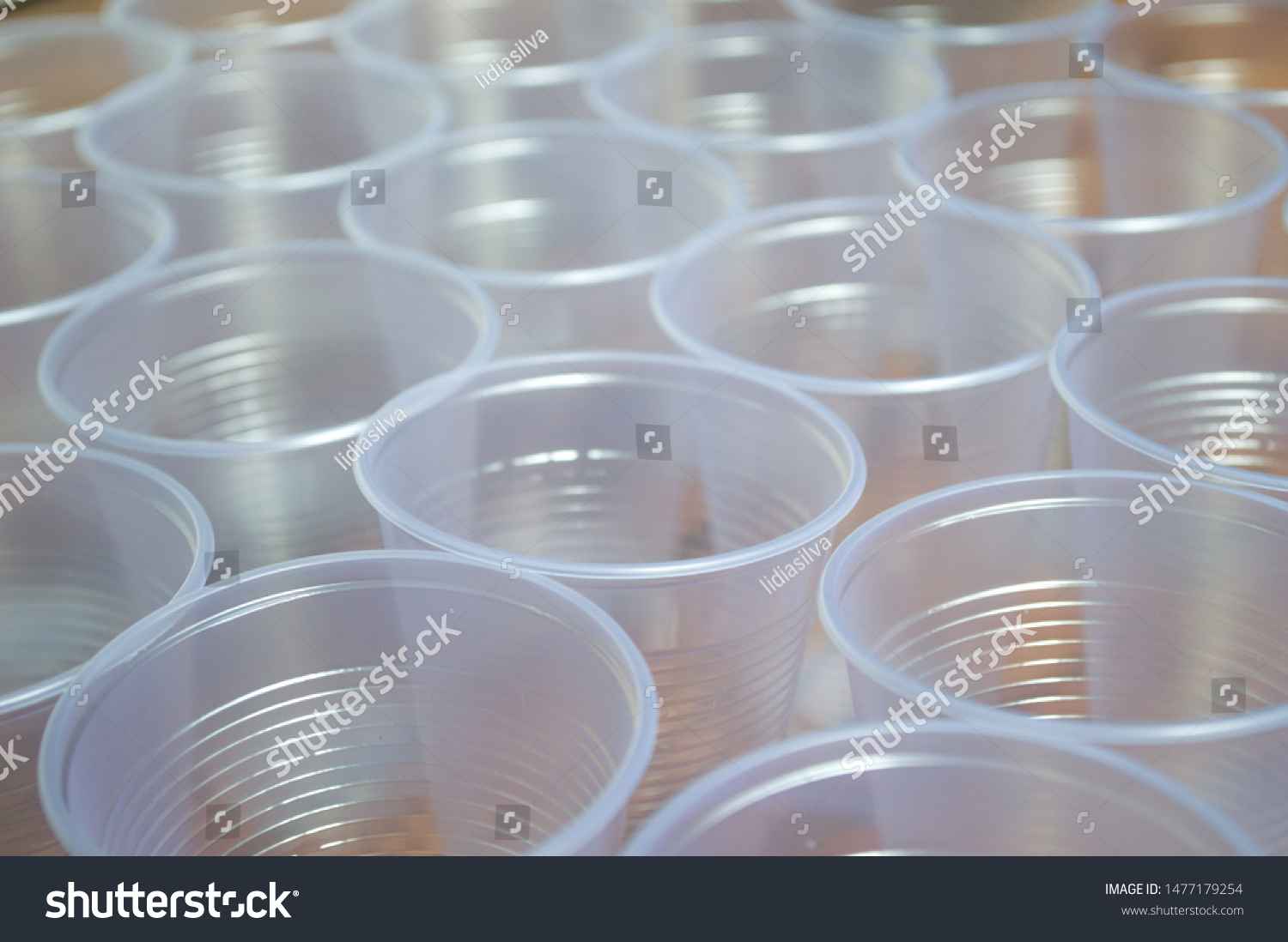 transparent disposable plastic cups on wooden table #1477179254