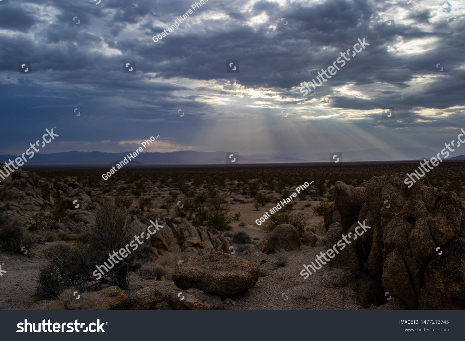 dramatic sunbeams penetrated the cloudcover over the desolate mojave desert #1477213745